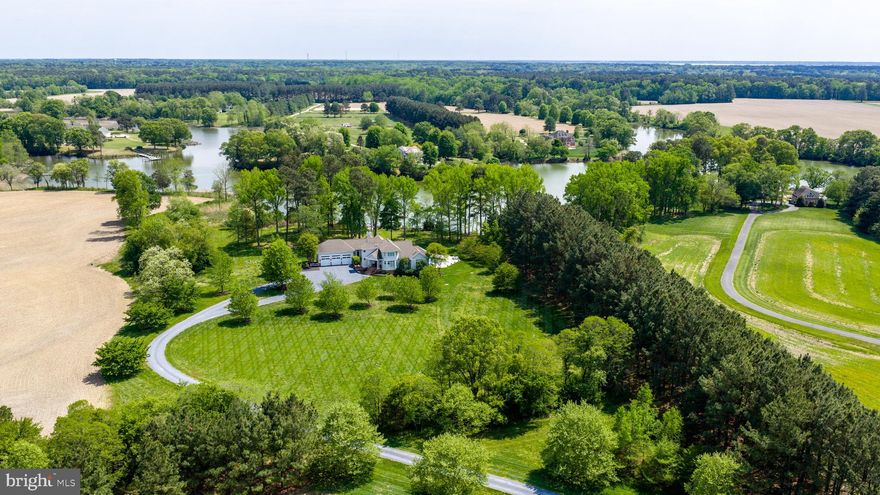 Set in the highly sought-after Patrick’s Plains community, 28211 Brick Row Drive is an exceptionally maintained and thoughtfully appointed waterfront residence overlooking the serene waters of Island Creek. Bathed in natural light, the home welcomes you with a stunning foyer and living room featuring floor-to-ceiling windows, skylights, and a gas fireplace, seamlessly connecting to the expansive deck. Designed for both everyday living and elegant entertaining, the home offers a formal dining area and beautiful hardwood flooring throughout. The gourmet kitchen is a true centerpiece, boasting a massive island, Viking gas range, Sub-Zero refrigerator, stainless steel appliances, and abundant pantry storage. Just off the kitchen, the family room impresses with cathedral ceilings, a gas fireplace, sweeping water views, and direct access to a screened-in porch.
The main-level primary suite is a private retreat, complete with a spacious walk-in closet and direct access to the back deck, where you can enjoy tranquil poolside and waterfront views. The luxurious primary bath features a cathedral ceiling, a standalone soaking tub, and a glass-enclosed shower. The lower level offers incredible flexibility as a poolside retreat or in-law suite, with its own living room, recreation space, bedroom, full bath, and kitchenette. Completing the home is a rare three-car garage, adding both convenience and functionality. The owner has completed many upgrades, including a new pool, pier improvements, three new HVAC systems, a new driveway, and a water treatment system, along with many other enhancements (full list available). With its prime waterfront setting, abundant natural light, and exceptional living spaces, this home offers a truly elevated lifestyle in one of the area’s most desirable communities.