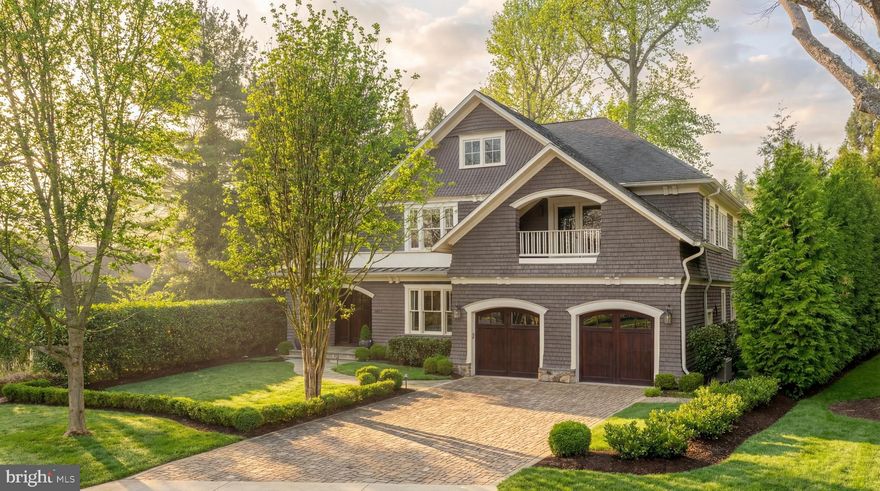 Prominently situated along a verdant curve in the heart of Bethesda’s prestigious Edgemoor community, one of the most coveted neighborhoods in the Capital Region, is 7602 Glenbrook Road. A stunning showcase of Cape Cod architecture, the home’s authentic shingled exterior is punctuated by dramatic archways and capped by cascading gables for a memorable initial impression. The combination of a paver driveway, flagstone walkway, and lush landscaping creates an elegant path to the solid wood and glass front door nestled within a recessed portico. It opens into a reception area, introducing a generous floor plan distinguished by elevated craftsmanship and spectacular recent improvements. Originally designed by Studio Z and constructed by Sandy Spring Builders, two household names for quality and attention to detail, the craftsmanship is evident in the details. Sophisticated millwork, outlets integrated into the baseboards, and rich, warm, wide-plank oak flooring throughout complement copious natural light and high ceilings. Formal spaces are generously proportioned and luxuriously outfitted, such as the living room which manages to retain a cozy ambiance, as well as the dining room, with its custom coffered ceiling. The butler’s pantry, a showpiece in and of itself, connects the latter to the chef’s kitchen, with both spaces having been fully transformed in 2024. Showcasing contemporary European-style cabinets and striking quartzite countertops and large-slab backsplash, the kitchen is the heart of the home. A custom hood, comprehensive suite of professional-grade Viking appliances, and beverage corner with glass cabinets round out the amenities. Adjacent is the large family room, anchored by a roaring fireplace framed with custom floor-to-ceiling cabinets, as well as an intimate breakfast nook set within a bay window, with two doors opening onto the rear patio. Upstairs, the primary suite is an oasis featuring a private sitting area with wooded views. The dressing room is lined with extensive built-ins, and the lavish primary bath was also completely redone in 2024 to showcase a double vanity with a whimsical mosaic backdrop, floating shelving, a freestanding tub, and room-sized, marble-clad walk-in shower. Three additional bedrooms, one with an ensuite bath and two sharing a large Jack-and-Jill, as well as a convenient laundry room, seating nook, and private balcony, complete the upper level. A hub for entertaining, the lower level revolves around a capacious recreation room offering the utmost in flexibility. A fifth bedroom suite enhances livability. The home’s outdoor space is both usable and private. Beautifully constructed, meticulously maintained, thoughtfully improved, and incomparably located within walking distance to downtown Bethesda’s urban core, 7602 Glenbrook Road is a rare offering in one of the region’s most sought-after locations.