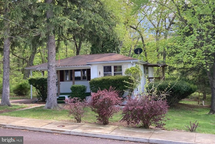 Cutest little bungalow ever, situated on a large wooded lot at the end of a quiet street in a great neighborhood.... Covered front porch and a carport with easy access to the front porch, ..also side entrance into the kitchen....living room has a large picture window and there is hardwood under the carpet, also in the two bedrooms...The kitchen is large, bright and cheery with plenty of counter space and table area, also a  washer/dryer hook up if you don't want to go to lower level to do laundry....the basement has interior steps as well as an outside entrance at the rear of the house, laundry area, newer gas heat and water heater....the yard is woodsy and level, lots of privacy....the house has been nicely maintained, and there is a security system