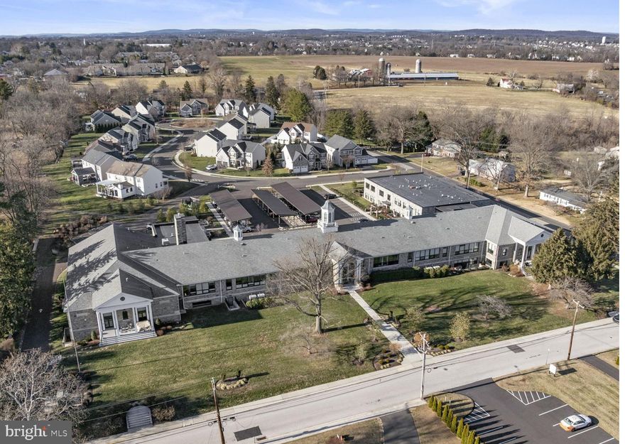 Discover modern living rooted in history with this stunning 1,789-square-foot garden-level condo perfectly situated within a converted historic grey-stone schoolhouse just two blocks from Ursinus College.  This luxury community is a perfect investment in a quaint college town.   C110 offers a quiet, more secluded environment in this busy stone school while being just steps away from all the community amenities including the community patio with grill & firepit; dog park, gym, art room, social room and deeded storage.  One of the many benefits of the garden-level units is having your own private patio that provides you with outdoor space for your own quiet enjoyment.   Whether reading, sipping a spot of tea or planting a container garden you have this retreat to call your own.  In a “best-of-both-worlds scenario”, if you want a more open-air experience, the community patio is literally just steps away!    You can’t beat a garden-level condo for the economic benefit of the earth’s natural insulation and retained heat and cooling and C110 still enjoys sunny blue sky and green views from its patio door and windows.    If you want more privacy then sun, you’ll enjoy the remote-controlled blinds that can be all the way up or down and, when down, can be open slats or closed.      Our pet-friendly environment is made easy at C110 with the steps and elevator just next door and the dog park just across the visitor’s lot.       Ultimately C110 delivers a lifestyle of quiet ease, elegance, economy and accessibility. It is a brilliant choice for anyone desiring low-maintenance, high-style living in a mostly single-level layout.    This beautiful home boasts high ceilings and an open-concept floor plan that creates an immediate sense of welcome.   The living area is centered around a cozy gas fireplace with an elegant stacked-stone facade, flowing seamlessly out to your own private patio for effortless indoor/outdoor enjoyment.    The highly functional sleek kitchen features quartz countertops; updated appliances; layered lighting and loads of storage space.  The living spaces flow effortlessly into two spacious bedrooms, each designed as a private retreat. You will appreciate the thoughtful storage solutions, including ample closet space to keep your life organized and clutter-free.  Luxury extends to the home's practical amenities, including a dedicated, full-size in-unit laundry. Indulge in the comfort of two and a half spacious, modern bathrooms, featuring sleek finishes and contemporary fixtures that transform daily routines into spa-like experiences.      Experience walkability to in-town dining—from casual spots to fine cuisine—shopping, parks, and scenic walking trails and the college campus.   With convenient commuter access and proximity to major job centers, this bright, airy, and truly spacious home is the perfect sanctuary, whether you are a first-time buyer, someone looking to downsize, or simply seeking an unparalleled lifestyle upgrade.