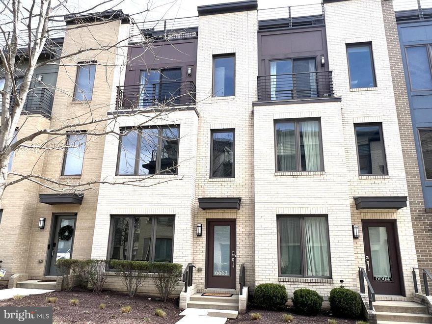 Live in Bethesda for under $1 million!  Enjoy comfortable, modern living in this beautifully designed four-story townhome in the vibrant Montgomery Row Community.  Built in 2017 by the highly regarded EYA Builders, this home showcases exceptional craftsmanship, elegant finishes, and thoughtfully designed spaces throughout—with over $113,150 in upgrades and enhancements. The entry level welcomes you with a spacious two-car garage, mudroom and a bright, versatile space ideal for a main floor bedroom, home office, or gym. Two additional parking passes—one for on-street parking and one for the corporate garage—add extra convenience. The main level features an open-concept layout perfect for both everyday living and entertaining. The gourmet kitchen is equipped with stainless steel appliances, a large center island with breakfast bar, pantry, and a private balcony with a gas line—perfect for grilling. The space flows seamlessly into the dining and living areas, highlighted by a cozy gas fireplace. Upstairs, the third level is dedicated to relaxation, offering a luxurious primary suite with a custom walk-in closet and a spa-inspired bath with a freestanding soaking tub. An additional bedroom featuring a Juliette balcony and its own bath plus a conveniently located laundry area complete this level. The top floor provides incredible flexibility, featuring a fourth bedroom ensuite, additional living space, and access to a stunning rooftop terrace with panoramic views—perfect for entertaining or unwinding. This exceptional home blends luxury, comfort, and convenience, with easy access to I-270, Westfield Montgomery Mall, the Transit Center, the local Preschool, Medical Offices, Shopping, and Dining—an outstanding opportunity to own in Bethesda you won’t want to miss. Located within a LEED-certified community, it also offers the added benefit of energy efficiency and sustainable living.