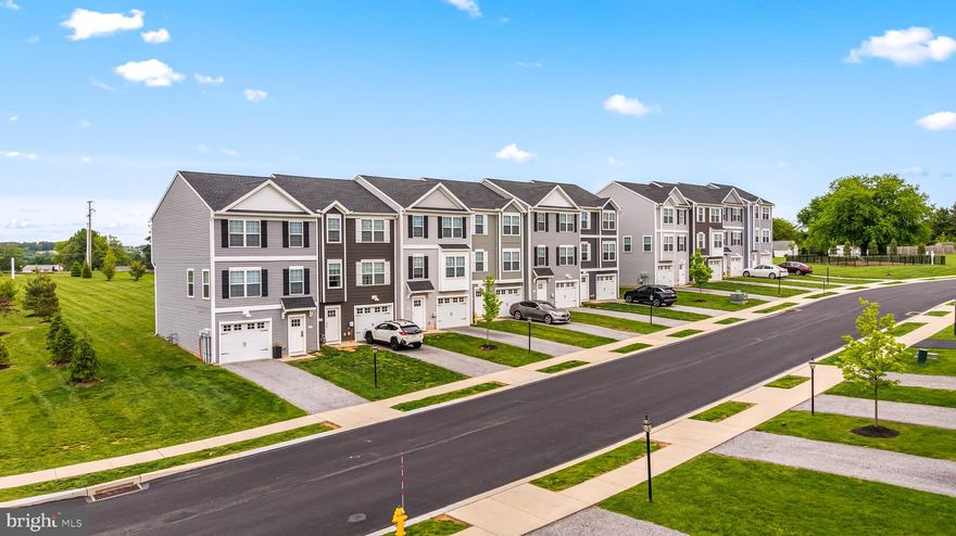 $5,000 in incentives* Welcome home to 452 Bradford Dr in Red Lion PA! Located in the Hudson Ridge community within the Dallastown Area School District, this newly constructed interior townhome offers approximately 1,900 square feet of modern living space with quick move-in opportunities available, as well as additional to-be-built options. Designed with a bright, open layout and 9+ foot ceilings throughout, this 4 bedroom, 3.5 bath home combines functionality, natural light and contemporary finishes in a convenient location. The main living level features an open floor plan connecting the kitchen, dining and living areas. The kitchen is equipped with granite countertops, an island, built-in range and microwave, stainless steel appliances including a dishwasher, and upgraded lighting fixtures throughout the kitchen and dining space. Sliding glass doors off the dining area provide access to an optional rear deck, while a conveniently located half bath completes the level. Luxury vinyl plank flooring runs throughout the first and second floors, enhancing the clean and modern design. Upstairs, the spacious primary suite features cathedral ceilings, ceiling fan, large walk-in closet and a private bath with a walk-in shower. Two additional bedrooms with carpet flooring and a shared full bath complete the third floor. The entry level includes a fourth bedroom with an attached full bath, offering flexibility for guests, office space or multigenerational living, along with interior access to the attached one-car garage. Conveniently located near Route 24, Route 74 and I-83, with easy access to York, Baltimore, Red Lion and surrounding commuter areas. Close to shopping, dining and everyday conveniences while offering low-maintenance new construction living. Schedule your private tour today!