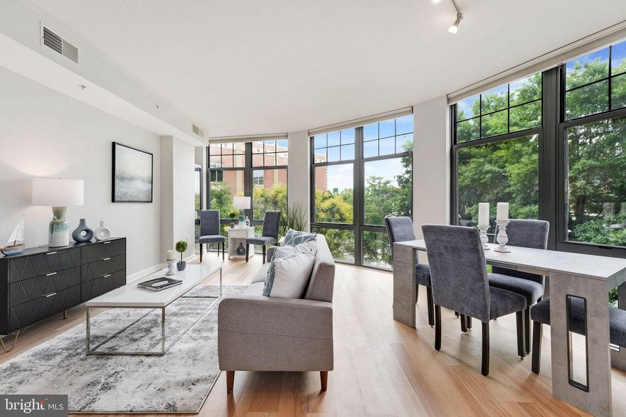 Welcome to Clarendon 1021 in the heart of Clarendon! This stunning condo offers the epitome of convenience, nestled in Arlington's vibrant urban village of Clarendon.  Just two blocks from the metro station, making commuting a breeze, while the nearby Whole Foods and Trader Joe's make grocery shopping a delight.  Indulge in the abundance of dining and shopping options right at your doorstep. From trendy eateries to chic boutiques, there's something for everyone within easy reach.
     Step inside to discover a well-designed space featuring two bedrooms and one bathroom. The open concept living area seamlessly integrates the kitchen, dining, and living room, creating an ideal space for entertaining guests or relaxing after a long day.  Large south-facing loft-style floor-to-ceiling windows on the entire exterior wall flood the space with natural light and offer picturesque views of the surrounding trees and Washington Blvd, creating a tranquil ambiance throughout.  The bright island kitchen features crisp white cabinetry, stainless steel appliances, and ample counter space for meal preparation. 
     Retreat to the primary bedroom, bright with large windows and complete with a generous walk-in closet with shelving and a secondary closet for added storage convenience. The second bedroom, located off the dining area, enjoys its own window and plush carpeting underfoot. The dual-entry bathroom boasts an oversized tub/shower combo, perfect for unwinding in style. Plus, the convenience of an in-unit laundry area with stackable washer and dryer ensures laundry day is a breeze. Need parking? This condo comes with 2 full-size garage parking spaces.
     Don't miss out on the opportunity to call this remarkable condo your new home sweet home. Schedule your showing today and experience the best of Clarendon living!