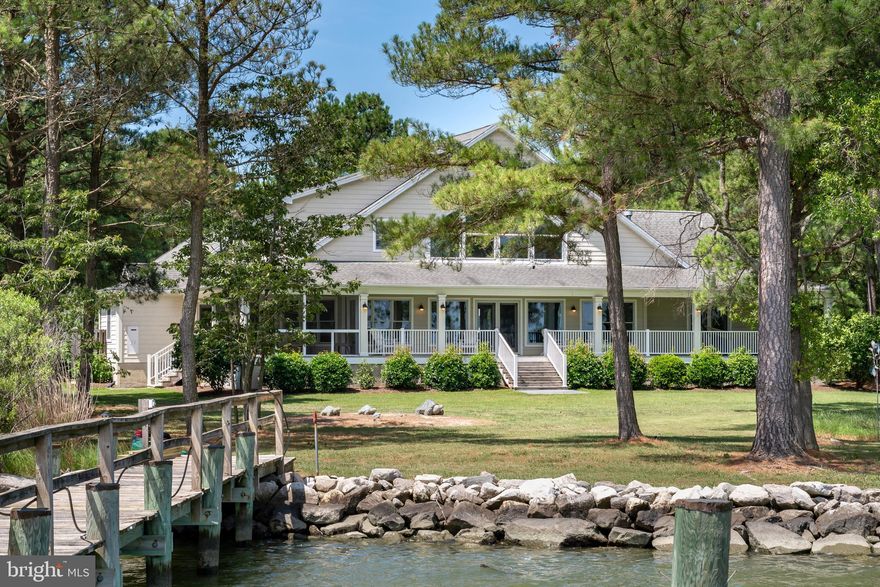 Welcome to your serene bayfront retreat on Maryland's beautiful Eastern Shore! This stunning property spans over 5+ acres, starting with a wooded entrance then opens to a lovely yard with gardens surrounding an extraordinary contemporary waterfront home.  With over 350 feet of rip-rapped and living shoreline on Brannock Bay off the Choptank River, and outfitted with a private L-shaped pier, boat lift, and floating kayak dock, this property takes great advantage of a location that offers some of the best boating and fishing on the East Coast and is just a short cruise to the open waters of the Chesapeake Bay.
** The home itself is a masterpiece of contemporary and functional design from start to finish.  Enter through the generous covered front porch into the foyer and main living area, all with hardwood flooring, where a wall of windows takes advantage of the home’s broad views of Brannock Bay.  The expansive Great room is filled with natural light, creating a warm and inviting atmosphere.  Along the entire waterside of the house is a broad covered porch offering numerous shady spots for hammocks and chairs as well as just off the kitchen a roughly 14 x 13 screened in porch for breezy, bug free dining.   To the right as you enter the home you will find the open kitchen and dining room while to the left, the private Primary Bedroom Suite awaits.  This suite includes a private bath with tub and separate shower, multiple closets including a large walk-in, and French doors that lead to the covered waterfront porch.  **  The right wing of this home features the kitchen equipped with stainless appliances, granite countertops, a large island with a gas stove and breakfast bar, a generous pantry as well as a waterside dining area.  Down the hall you’ll find a spacious full laundry room with storage as well as a full bath and a beautiful guest bedroom with private outside access.  Up the stairs from the laundry are two additional finished rooms ideal for office, craft room, and extra storage. This wing also includes a mudroom through which you access an over-sized three car garage which, in addition to protected parking, offers ample storage space for bikes, boats, paddle boards, fishing rods and more.
**   Up the beautifully designed stairs off the Great room to the second floor, you will discover an open family room ideal for relaxation and entertainment which also offers spectacular views of the property and Brannock Bay.  There is also a second comfortable Primary Suite with a full bath and balcony overlooking the Great room.  **  Owners made significant improvements to the property since purchase including a boat lift, screen porch, outdoor shower, HVAC air unit and complete duct work replacement, Pella windows, kitchen stainless appliances, artistic contemporary lighting, kitchen sink and granite countertops, interior painting, exterior shutters and a brand-new Rinnai hot water heater.  Most furnishings and boat negotiable. New Boundary survey in hand which shows room for a pool on the water side, buyer to confirm details with pool company. $225 Association/Community annual fee for 2024.