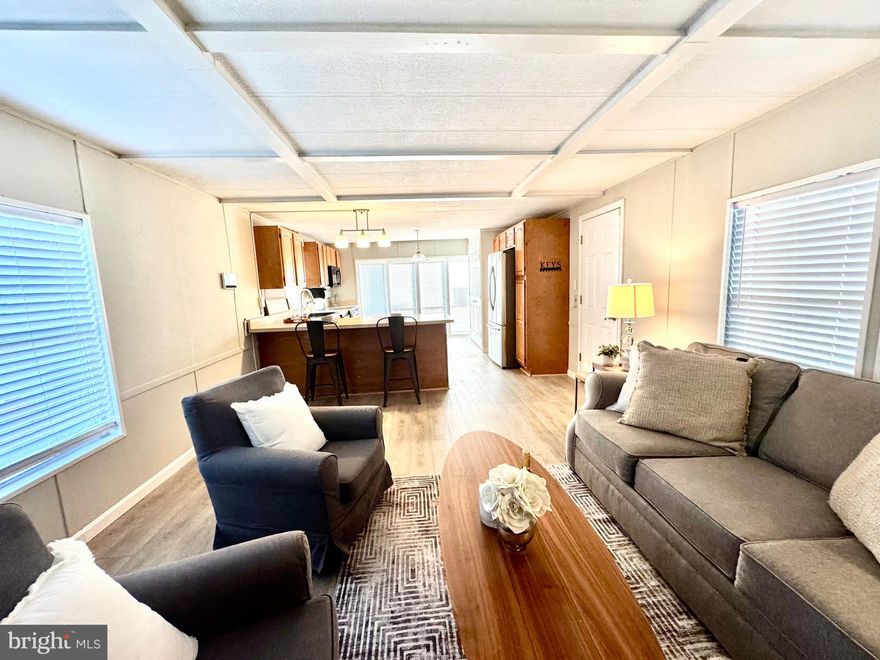 Temp off due to some updates needed.  Come see this super cute mobile home with a huge open concept kitchen! Home has been professionally painted, new LVP flooring, Large covered deck, parking for 3 vehicles, fishpond, nice side yard with a patio. HVAC system replaced in 2025. Must be park approved. Monthly lot rent is currently $843 per month which covers trash, water, sewer and there are no monthly taxes on mobile homes.