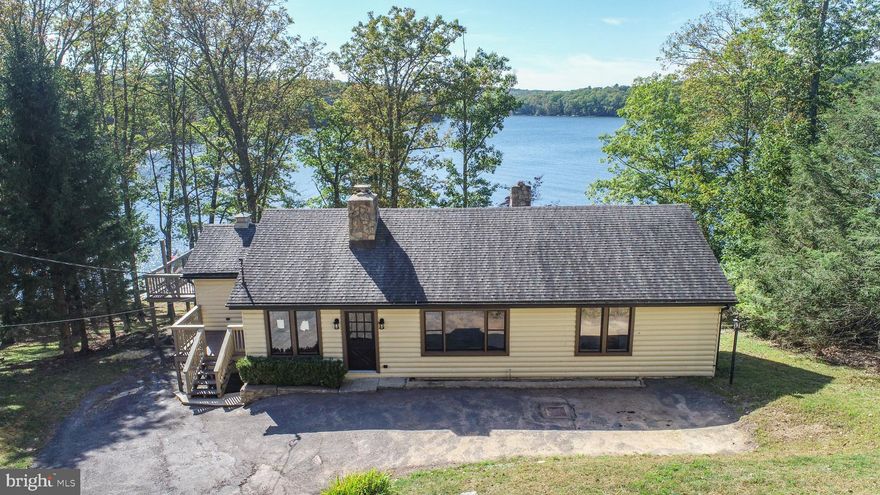 Welcome to your dream getaway at Deep Creek Lake! This fully renovated 4-bedroom, 3.5-bath lakefront home offers the perfect blend of rustic charm and modern comfort, with breathtaking lake views and 114 feet of prime frontage.

Inside, you'll find a spacious and thoughtfully updated interior, including a main-level primary suite for ultimate convenience and privacy. The gourmet kitchen features high-end finishes and modern appliances, ideal for hosting family and friends. Cozy up by the stunning stone fireplace in the living area, where vaulted ceilings and warm wood accents create an inviting mountain-lodge ambiance.

Step outside and enjoy your own slice of Deep Creek paradise with a Type-A dock permit, allowing space for 2 power boats and 1 non-powered vessel. The newer W-shaped dock makes lake living easy and luxurious—perfect for swimming, boating, or simply relaxing by the water.

As a major bonus, this property includes a massive 3-level garage building, offering a world of possibilities: create an indoor pool, a game and hangout area, use it for boat or gear storage, or finish it out as additional living space—your imagination is the only limit.

Whether you're searching for a full-time residence, vacation home, or high-demand rental investment, this lakefront gem checks every box.

Schedule your private tour today and experience Deep Creek Lake living at its finest!