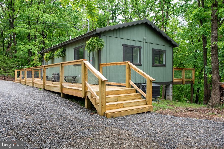 You do not want to miss this newly renovated home with all new systems, appliances and roof.  Situated on just over 2 wooded acres, in the tranquil Lost River Valley of West Virginia you will feel a world away and still have access to all the modern conveniences including Fiber Optic internet. Meticulously renovated this home provides privacy and serenity, making it an ideal haven for those looking to escape the hustle and bustle of city life. Inside features an open living space with a wood-burning fireplace that is perfect for cozying up on chilly evenings and seamlessly integrates with the intimate and modern kitchen. The large windows allow for abundant sunlight to fill the space and the views of the surrounding wooded acres from every room provide a connection with nature creating a serene and relaxing environment. Step outside onto the wrap around deck and a screen room  with indoor/outdoor LVP flooring that is ideal for enjoying your morning coffee or hosting a summer BBQ.  Step off the porch and onto the gravel path that takes you over to the fire pit for an evening of star gazing and s'mores. The community of Snyders Ridge has minimal restrictions and a lovely park-like setting and is so quiet that the road is a perfect trail for evening strolls. Don’t be surprised if while you are meandering along you are invited in to one of the neighbors’ homes for libations and delightful conversation. Located just a short drive from George Washington National Forest, Trout Pond Recreation Area and under 3 miles from Lost River State Park, outdoor enthusiasts will appreciate the abundance of hiking, fishing, horseback riding, swimming and other recreational opportunities in the area. Lost & Found Pizza & Provisions is just a 5 min drive offering hand-tossed wood fired pizza and a curated beer, wine and snack selection you are bound to love.  Hit the LRV Gym for a quick workout and grab lunch or dinner at Lost & Found Pizza and Provisions. Don’t forget to grab a bottle of wine or your favorite craft beer from the Provisions Store.