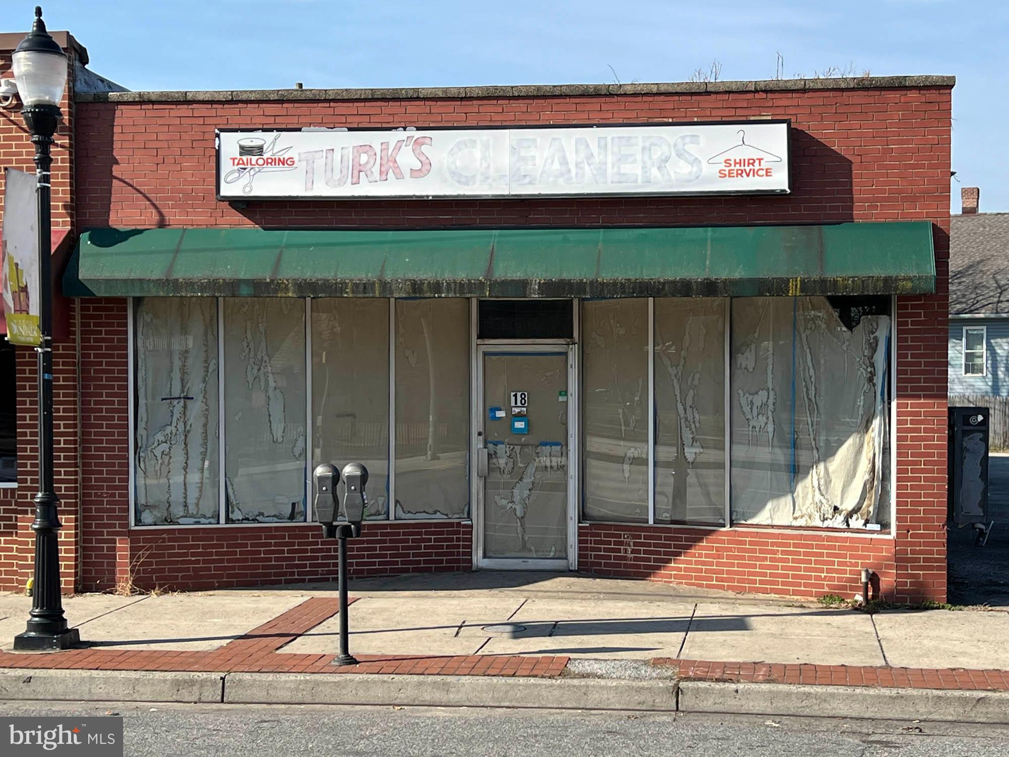 REAL ESTATE AUCTION featuring ON SITE and SIMULCAST ONLINE BIDDING!! Online Bidding Opens - Monday, March 25, 2024. Live On Site Auction - Tuesday, March 26, 2024 at 12:00 Noon. List price is opening bid only. One Story Brick and Concrete Block Commercial Building, built in 1962, containing 2,500 square feet of gross building area, according to public tax records. The building has an aluminum storefront with show windows, built-up roof and front and rear entrances. An attractive mural of Dundalk is painted on the side of the building, facing a large public parking lot.
The building is in shell condition and comprises open span space with unfinished concrete floors. The current occupant was in the process of remodeling the space into a nail salon. Plumbing has been installed along the south wall of the building. There is new electric wiring, aluminum studding and three new 2.5 ton roof-mounted electric HVAC units. The work is not complete and the roof is leaking. The location is excellent and the building has good potential for a variety of retail or service uses.