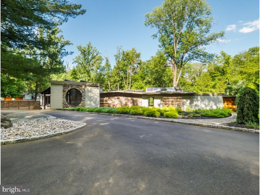 The rarest of opportunities to own a piece of artistic history has arrived. Designed and built by renowned woodworker George Nakashima, 1886 Aquetong Road is set across from the famous workshop and studio complex that is still used by his daughter to create furniture in his influential style.  Surrounded by Zen gardens and adorned with stone terraces the Japanese influence on this property is clearly evident. Stepping through a custom glass entry displaying a live edge wood embellishment the foyer greets you with gorgeous walnut wood floors, a large circular picture window, skylights in the exposed beam ceiling and a tiered stone koi pond that gives this home a complete sense of peace and calm.  Truly stunning the living room is enriched with tri-colored black walnut paneling and floor, as a skylight and directional light compliment the fireplace. The pitched balsa wood ceiling adds another touch of design brilliance to the space, while a customary Tokonoma tree post honors visitors and can be part of the traditional Japanese tea ceremony. A fundamental simplicity understood the world over allows the one-of-a-kind SieMatic kitchen to be its own showcase as the luminosity of black granite counters and lacquer finishes give the chef and open workspace with double oven, oversized basin and sightlines across the main living areas.  The formal dining room has the distinction of the embellished walnut panels, bamboo ceiling and two sets of mini French doors that reveal an art gallery.  Four large glass panels frame the gardens so they can be enjoyed from the family room where terra cotta tiling, six skylights, two beautiful lighted ceiling fans create a symmetrical look blended with a warm ambiance. There is also a wet bar area, with sub zero fridge and long stretches of built-in counters for an abundance of organized storage. Additional glass doors open to a stone patio.  Appreciate and share your fine art in a wide gallery style space that wraps around to the guest suite and a full bath with glass shower that has a sandblasted design. A tranquil, peacefulness will wash over you in the master suite where the zen quality design includes a wall of glass so you can take in the garden view from the moment you rise, a sitting area and dual, fully customized walk-in closets. The lavish master bath features a marble shower bay, double vanity, soaking tub with marble surround, opaque divided glass windows and striking lighting fixtures. New two car garage, storage abov