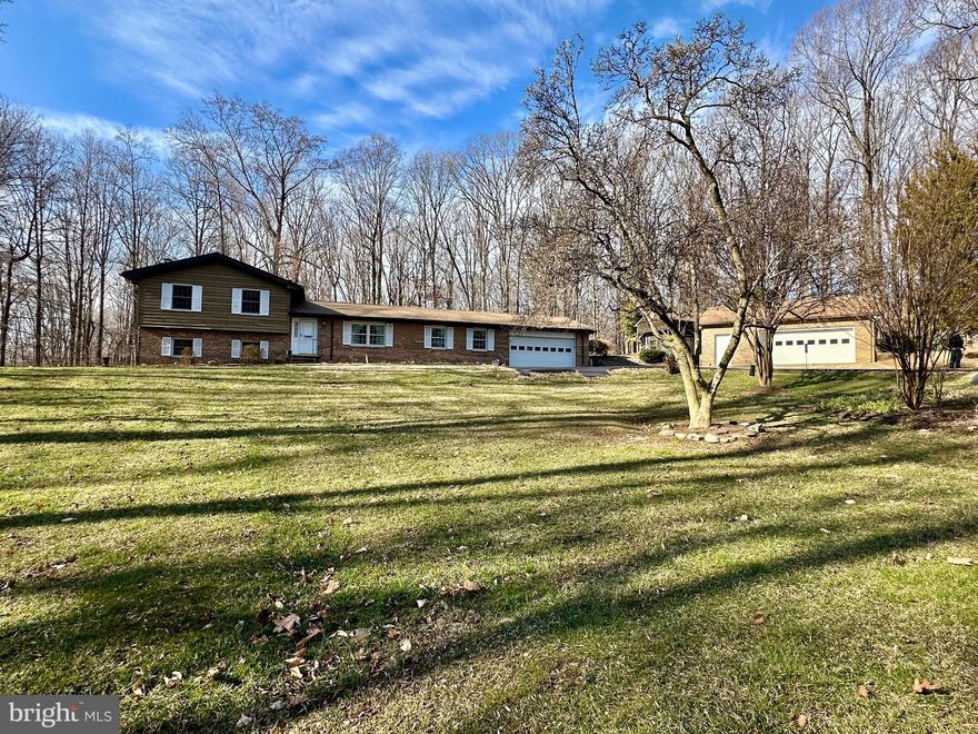 ON MARKET FEB 2 - PHOTOS COMING SOON! THIS PROPERTY IS NOT OPEN FOR WALK-INS OR PROPERTY WALK AROUNDS. UNAUTHORIZED ENTRY TO GROUNDS IS TRESPASSING. SHOWINGS BY APPOINTMENT ONLY. PROPERTY IS MONITORED.
First time offered!  Spacious brick-front home on 3 private acres and no HOA!
Set back from the road behind a paved driveway and framed by professional landscaping and flowering perennials, this impressive brick-front split-level home offers a lifestyle of peaceful enjoyment surrounded by nature.  Situated on three private acres, this property is a rare find for those seeking a classic, solid home. 
Entirely livable as-is, clean and meticulously maintained, this property waiting for you to bring your vision to life.  Featuring Anderson windows, newer roof and furnace, a whole house generator system, and appliances that look like they’ve never been used!
And what about the ultimate garage setup? This property is a dream for car enthusiasts, craftsmen, or anyone needing massive storage!  The 2-car attached garage is perfect for daily drivers providing quick access to the mudroom and the 2+ car detached garage is an expansive secondary structure ideal for a workshop, boat storage, or a classic car collection.
The main level of the home features a slate entryway, large living room/dining room combo, pristine kitchen, finished sunroom, very large family room, and a mudroom big enough for that extra fridge and freezer as well as additional storage.  
The lower level offers a great home office/craft room with a wall of closets and shelves, a full bath with updated tiled double shower, and another family room/bonus room with wood burning fireplace.
Upstairs you’ll find another full bath and two large bedrooms with generous closets in addition to master bedroom which offers a walk-in closet and large master bath with updated tiled double shower.
If you’re looking for privacy but with an easy commute to DC and Annapolis then this property is definitely worth checking out!  ESTATE SALE - SOLD AS IS