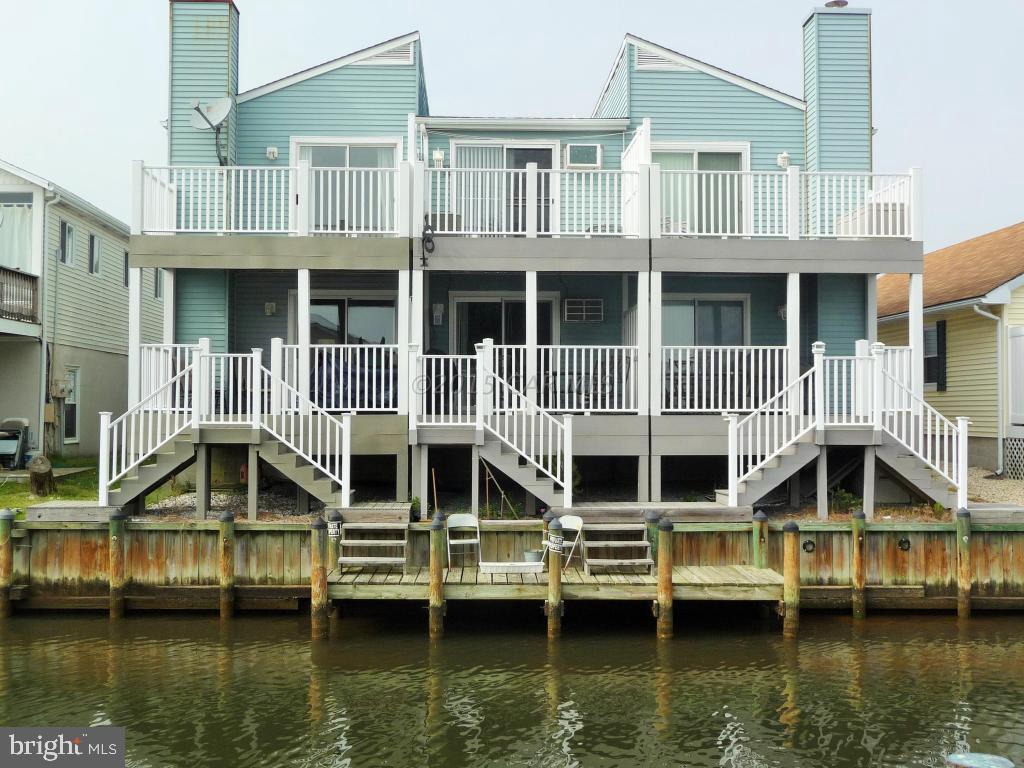 Great waterfront townhome with shared dock. Remodeled and beautiful! Easy care laminate flooring in Living Room and ceramic tile flooring in the kitchen, dining area and baths. You will enjoy the waterfront porch and the private deck off of the 1st bedroom. The wood burning fireplace will keep you toasty in the winter. Just a 7 year old roof with a 30 yr warranty. 3 Ceiling fans. Super location - so close to the beach entertainment and restaurants. 136th Street traffic light makes it easy cross to the beach. Custom painted and ready to enjoy! Easy care decking and railings too. Nicely furnished. Listed $15,000 less than recent appraisal. This is a great buy!