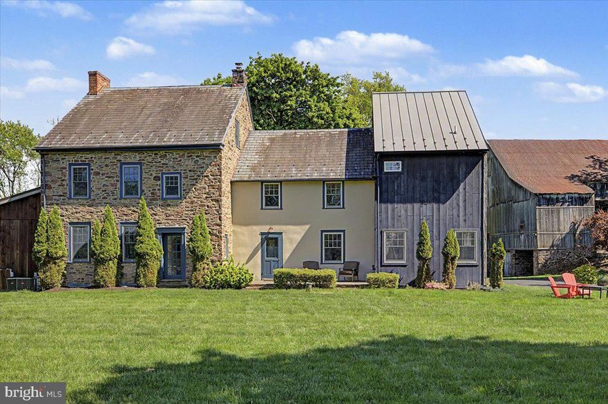 A rare Bucks County offering where timeless heritage meets modern country living. Set on nearly three picturesque acres, this exceptional historic farmhouse—originally built circa 1770 and thoughtfully expanded through 2019—blends the romance of a classic Pennsylvania stone home with the comfort and functionality of modern living. Offering approximately 4,000 square feet with six bedrooms and three-and-a-half baths, the property provides a refined sense of privacy just minutes from Doylestown, parks, and everyday conveniences.
Original architectural details including wide-plank floors, deep windowsills, and decorative fireplaces are beautifully paired with purposeful updates throughout. At the heart of the home is a custom Canaan Cabinetry kitchen with soapstone countertops and Miele appliances, designed for both everyday living and entertaining.
The outdoor spaces are equally compelling. A rustic covered porch overlooks the saltwater pool, while expansive grounds feature a basketball half-court, zip line, garden, and open lawn areas ideal for recreation, gatherings, or simply enjoying the surrounding landscape. A historic bank barn adds character and future potential, creating a setting that feels both timeless and inviting.
Located in Bucks County with convenient access to Doylestown, parks, trails, schools, shopping, and dining, the property offers a unique blend of privacy, open space, and accessibility. A truly distinctive estate where history, land, and modern living come together beautifully.