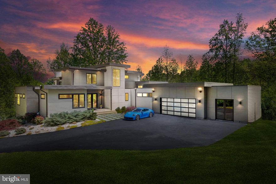 Introducing a captivating architectural gem nestled on a private 2-acre parcel. This refined and unique dwelling epitomizes contemporary design and upscale living. Upon arrival, you'll be captivated by its impressive facade featuring a durable 30-year TPO roof, stylish hardiplank siding, and black Pella Architectural Series casement windows. A welcoming 9-foot glass entrance seamlessly integrates with the lush surroundings and meticulously crafted outdoor space. Upon entering, this bespoke luxury home immediately captivates with its impeccable attention to detail and breathtaking aesthetics. The harmonious blend of sleek lines and classic color palettes leaves a lasting impression. The first floor is graced with expansive windows, luxurious plank bamboo flooring, and sturdy 8-foot core interior doors. The main level living area boasts a soaring 20-foot ceiling adorned with a mesmerizing stone feature wall and a contemporary linear gas fireplace complemented by a floating mantel. Culinary aficionados will delight in the gourmet chef's kitchen, featuring custom cabinetry, a spacious 9-foot island, pristine quartz countertops, and a convenient custom walk-in pantry. Expansive glass doors lead to a sprawling deck with refined steel cable railings, offering an idyllic outdoor retreat overlooking the inviting saltwater pool and charming fountains. Additional rooms on the main level feature lofty 10-foot ceilings, including the luxurious primary suite with a generous custom walk-in closet. The opulent primary bathroom offers a spa-like sanctuary, boasting a freestanding soaking tub and an oversized glass-enclosed shower. Dual quartz vanities and elegant tile flooring complete the lavish ambiance. A full-scale home office with custom bookshelves and storage on the main level caters to busy lifestyles, providing a serene workspace and added convenience. A second main level suite with its own bath ensures privacy and comfort for guests or family members. Adjacent to the garage, a mudroom with built-in cubbies and a spacious laundry room adds practicality. The second floor unveils two generously sized bedrooms, a spacious loft ideal for movie nights or relaxation, and a modern full bath appointed with modern fixtures. The walk-out lower level boasts 9-foot ceilings and abundant natural light, perfect for entertaining guests at the custom-built bar with quartz countertops and textured tiles. An expansive open recreation area offers a linear electric fireplace and custom built-ins, creating a setting for relaxation. Completing the lower level are a full-sized bedroom, full bath, bonus room and game room. A private studio, accessible from the garage or exterior entrance, has 12-foot ceilings, an elegant wainscot feature wall, and waterproof vinyl flooring, a versatile sanctuary suitable for a gym, studio, or additional office space. Walk outside of the basement level to a cozy patio with a gas firepit and plenty of seating, providing an outdoor haven for peace and socializing. The sparkling saltwater pool serves as the focal point of relaxation, providing months of rejuvenation and pleasure. You are just 4 miles south of 50 and 10 miles from downtown Annapolis. Convenient to Baltimore, BWI, Ft. Meade/NSA and Washington, DC. You literally have the best this region has to offer in a 30-mile radius. Welcome Home!