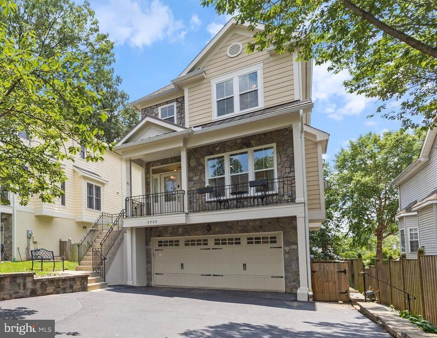 Stunning Craftsman in Coveted Ellison Heights! This elegant 4 bedroom, 4.5 bath Craftsman-style charmer, built in 2007, is perfectly nestled on a beautifully landscaped garden lot just ½ mile from the West Falls Church Metro and the vibrant shops, restaurants, and cafés of downtown Falls Church City.
A welcoming and stylishly-tiled covered front porch sets the tone for the sun-drenched interior, where three finished above-grade levels offer space, light, and timeless style. Inside, you’ll find oversized windows, gleaming hardwood floors, custom moldings, and a graceful layout anchored by a magnificent central staircase with soaring sightlines. The living room features a handsome gas fireplace, while the elegant dining room includes a stylish wet bar—perfect for entertaining. The gourmet island kitchen is a chef’s dream with stainless appliances, quartz countertops, and ample prep space. The adjoining breakfast nook and cozy family room provide ideal spaces for casual living. Step outside to the elevated deck with convenient hard-plumbed gas grill and enjoy tranquil garden views—perfect for outdoor dining or weekend relaxation. Upstairs, each of the three spacious bedrooms has its own full bath. The luxurious primary suite is tucked at the rear of the home and features garden views, abundant closets, a sitting room, romantic fireplace and a spa-like bath with dual vanities, seamless glass shower, and jetted tub. A convenient laundry room completes the upper level. The walk-out lower level offers remarkable flexibility with a sunny rec room that has its own office area with built-in desk and cabinetry.  Adjacent to the rec room is a 4th bedroom that converts easily between a bedroom suite or home office with a Murphy bed tucked behind a custom bookcase, a heated floor and sliding glass doors to a private, covered stone patio.  A full bathroom completes the lower level. Additional highlights include an oversized two-car garage, new Pella windows, upgraded HVAC, tankless water heater, multiple new appliances, whole house generator and enchanting outdoor spaces with mature plantings, stone hardscaping, and lush garden vistas. All just steps from neighborhood parks, the W&OD Trail, West Falls Church Metro, and easy commuter routes to Tysons, McLean, Arlington, and DC. Located in the Haycock / Longfellow / McLean school pyramid. This exceptional home offers the perfect blend of charm, comfort and convenience. Sellers have respectfully requested that any offers be submitted by 2:30 pm on Monday 7/21.