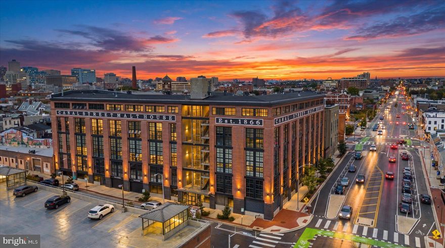 There’s a certain ease to life here, where light pours in, the city feels within reach, and every detail has been thoughtfully considered.

Ideally located on the fourth floor of the Canal Street Malt House, this residence is defined by its dramatic floor-to-ceiling windows, framing captivating views of the Harbor East skyline. From morning light to evening glow, the home is constantly shifting in the most beautiful way; bright, open, and effortlessly inviting.

The main level is designed for both everyday living and entertaining, anchored by a chef’s kitchen complete with a Wolf range, wine refrigerator, and an expansive island that naturally becomes the heart of the home. A main-level ensuite bedroom offers flexibility and comfort, whether for guests or a more private retreat.

The second-floor primary suite feels like its own quiet escape. Lofted and open, yet deeply private. Thoughtfully scaled, it features an expansive walk-in closet and a spa-inspired bath with a soaking tub, creating a place to truly unwind at the end of the day. Just beyond, a spacious balcony overlooks the building’s landscaped courtyard; an unexpectedly serene backdrop in the middle of Little Italy. Throughout, generous proportions set this residence apart as one of the larger floor plans in the building, offering a sense of space that’s increasingly rare in city condo living.

Garage parking with one assigned space adds a layer of convenience to an already elevated lifestyle.
See why the Canal Street Malt House is one of the most coveted addresses in Baltimore. In the heart of Little Italy, a few blocks from Harbor East, waterfront promenades, and some of Baltimore’s most beloved dining destinations, this is city living at its most refined.