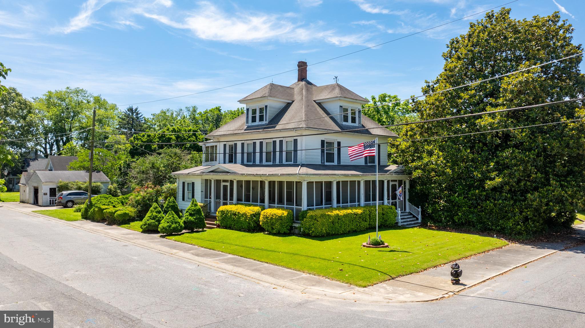 This 3-story Edwardian-style gem offers timeless charm and modern comfort. Nestled on a beautifully landscaped corner lot with two detached garages, this home features a wrap-around porch with ceiling fans and anchored lighting, original hardwood floors, high ceilings, and stained-glass accents.
Enjoy 4 spacious bedrooms, a full in-law suite, and a flexible third-floor bonus area with cedar closet. The primary suite opens to a screened sleeping porch—perfect for quiet mornings. A brick walkway winds through the included adjacent lot to a serene seating area and goldfish pond.
Extras include 2 HVAC units (1 & 5 years old), new 50-gallon water heater (2025), public water/sewer, a finished basement, and more. Located just steps from the Pocomoke Fairgrounds. A true historic treasure—welcome home!