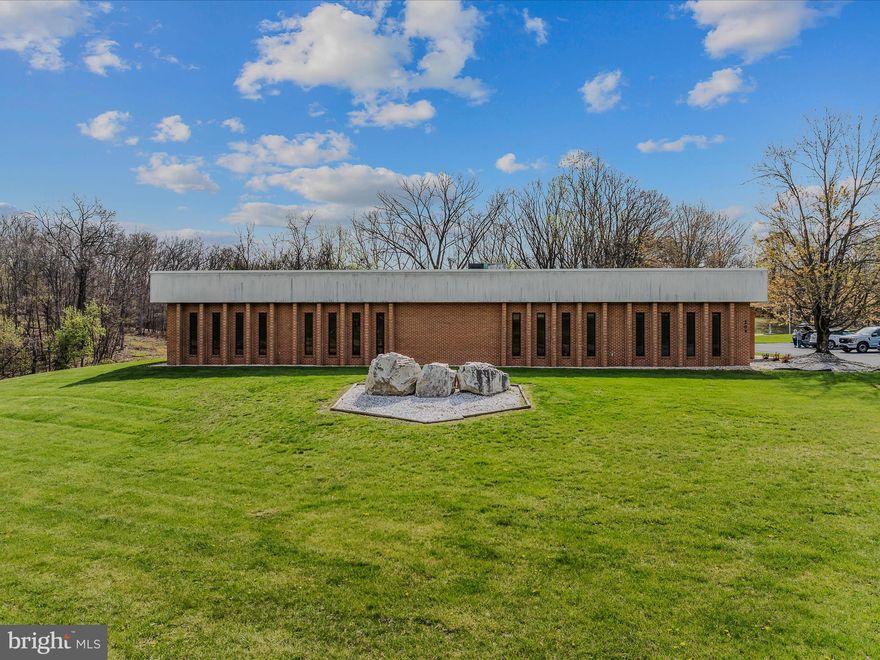 Amazing mixed-use office space like this only comes along once in a blue moon! This all-brick, one-level commercial building offers 8,835 square feet of flexible space and is move-in ready for your business. Situated on a 1.02-acre lot with a private paved parking lot, sidewalks, and concrete pads, the property has no deed restrictions, offering endless possibilities for use. Its prime location just 2.15 miles north of downtown Berkeley Springs and only 4 miles from I-70 ensures excellent visibility and easy access directly from US Route 522—a major plus for any commercial operation.
Inside, the building is thoughtfully laid out with a welcoming reception area, seven private offices, two conference rooms, a break room, three half-bathrooms, a shower room, a room housing all power components, two large storage rooms, and a spacious open floor area. The raised false flooring system allows plumbing and electrical lines to run beneath the surface, making reconfiguration for different layouts or uses simple and efficient.
Interior finishes include a combination of carpet and tile flooring, drywall walls, acoustic tile suspended ceilings, and solid wood doors. Heating and cooling are provided by a mix of electric baseboard and heat pump systems. The bathrooms feature tile flooring and wainscoting, along with drywall walls and ceilings, and the shower room includes a single shower stall.
Whether you're looking to expand, relocate, or launch something new, this property offers the space, flexibility, and location to make it happen. Don't miss this exceptional opportunity to own a standout commercial building in a growing area! MOST FURNISHINGS WILL CONVEY