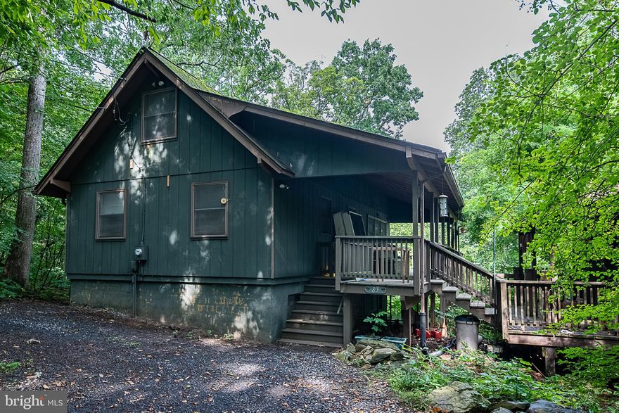 Now is your chance to own a little piece of heaven, here on Blue Mountain. This 2-bedroom 2-bathroom Chalet style home is ready for you to come and make it your own. Additional lot conveys with the sale of the property totaling 1.51 acres. With some work, this home would be a perfect place to have a retreat for you and your family or come live the mountain life and reside here full time. If you are into wood working, crafting or building, then check out the 2-level workshop off the deck. The current owners created a lot of beautiful wood working projects from this space. The lower level of the shop is another great option for storage. This property boasts the primary bedroom on the main level with an ensuite bathroom and a huge walk-in closet. Do you not plan on staying here full time? You can convert the walk-in closet back to the additional bedroom it once was, to sleep more.  The basement has a finished recreation room with a bonus room that may be able to be converted into another bedroom. There is an extra room off the bonus room that is ready to be plumbed for an additional bathroom. During the fall and wintertime, take a seat on the deck, or the patio below where you will be able to enjoy the views of the valley through the trees.  Screen in part of the MASSIVE patio, use part of it for storage, or keep it open, the options are endless.  The woodstove in the living room sets the mood for you to be able to enjoy watching the snow silently fall while keeping toasty. Blue Mountain is also the home to Blue Mountain Lodge Venue which boasts stunning scenery. The community offers access to Deer Lake, which has a well-kept sandy swimming area and a large floating dock that allows access to the center of the lake. Take a leisurely float and enjoy the water.  Enjoy watching the wildlife and walking around in the lush forest.  It's a visually stunning area and a gem hiding just outside DC.