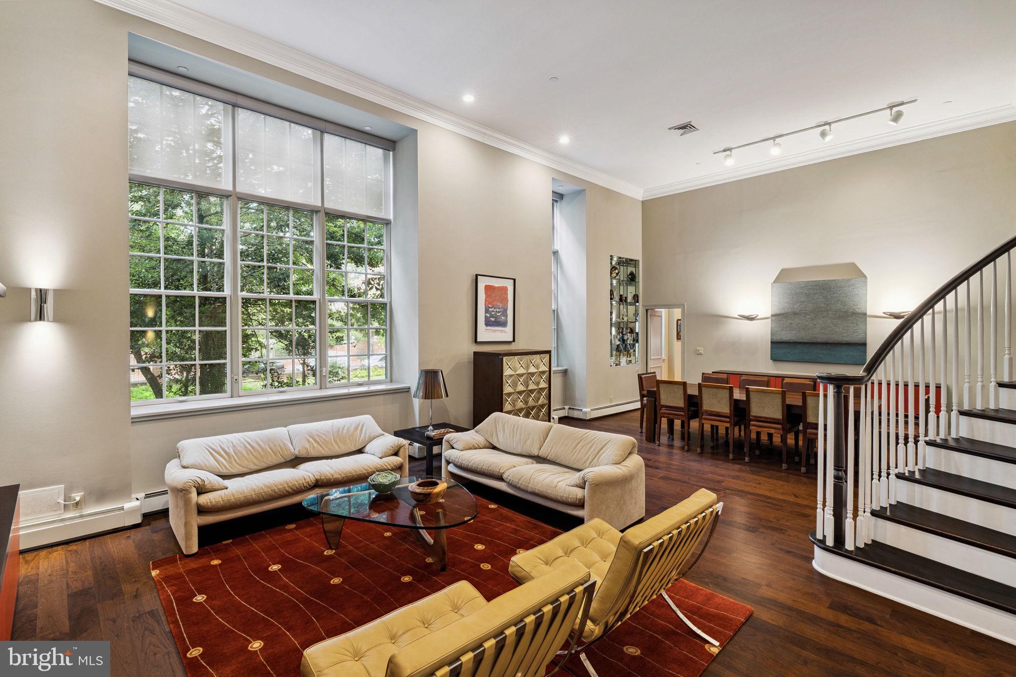 Spectacular home with a seamless combination of beautiful original character and modern updates at The Willings at Independence Park in the heart of Society Hill. This beautifully appointed home known as Buford Manor is the largest residence available in the building. It features four bedrooms (or three plus den), three full bathrooms, a powder room, great entertaining space, high ceilings, new hardwood floors, and a deeded parking spot. Upon entering there is a grand foyer with a soaring ceiling, conveniently located powder room, and coat closet that leads to the magnificent great room. The expansive great room enjoys massive windows providing excellent natural light, a beautiful curved staircase that leads to the lofted bedroom/den, a 14-foot high ceiling, and an open living and dining space, perfect for entertaining. Both the living and dining area enjoy recessed lighting and custom built-ins with storage. The dining space can easily fit a 12-person table and has custom built-in display shelves with accent lighting. Adjacent to the dining area is a modern eat-in kitchen with sleek wood cabinetry, solid surface countertops, instant hot water faucet, breakfast bar, mirrored backsplash, and a state-of-the-art stainless steel appliance package including a Wolf microwave and oven, Wolf gas range and hood, wood paneled Sub-Zero refrigerator, and ASKO dishwasher. The large primary suite enjoys more oversized windows, a high ceiling, two walk-in closets and an ensuite marble appointed bathroom with modern double vanity, bathtub and separate glass enclosed shower. Up a small flight of stairs are two generously sized bedrooms with oversized windows, high ceilings, and excellent closet space that enjoy use of a full hall bathroom with modern vanity and glass enclosed tub shower. One bedroom is currently being used as an office and features a full wall of custom built-in shelving and storage. Up the gorgeous curved staircase is the fourth lofted bedroom that overlooks the great room. It is currently being used as a den and features custom built-ins, a walk-in closet, and a full ensuite bathroom with modern vanity and glass enclosed tub shower. There is also a laundry room with side-by-side Maytag washer and dryer and a walk-in storage closet off of the foyer. Additional home highlights include a new HVAC system with Nest thermostat, beautiful trim and millwork, crown and baseboard molding, custom light fixtures, and recessed lighting throughout. A climate controlled storage unit is also included with the home. The Willings at Independence Park is a historic boutique condominium building with only 23 residences offering ornate historic details from the late 1800s and incredible privacy. The Willings named after Thomas Willings was the original headquarters for the Reading Railroad (a property in the game Monopoly!) in 1871 and boasts the largest concentration of original 18th and 19th century architecture in the United States. Residents enjoy a 24-hour doorman, concierge and on-site manager. The building is located in the heart of Society Hill walking distance from Washington Square, Independence Hall, world class dining, shopping, museums, and historic sites.