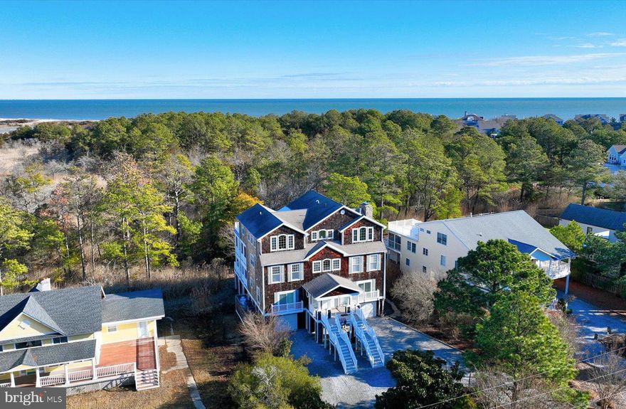 Perfectly positioned for exceptional privacy, 22 Farview Road in North Shores occupies a coveted perimeter parcel overlooking protected state park lands, with serene natural views stretching as far as the eye can see. The home’s stately cedar shake elevation exudes timeless coastal charm, while multiple levels of screened porches and balconies invite outdoor living into everyday life—offering peaceful vistas of trees, wetlands, and even a distant view of the ocean. Inside, the welcoming entry foyer opens to the first level, which hosts four generously sized bedrooms, each with its own private en-suite bath—ideal for family and guests alike. The second level is thoughtfully designed for both entertaining and relaxed coastal living. Here, the grand great room is anchored by a striking stone, wood-burning fireplace and flanked by rich custom built-in cabinetry. Additional spaces include a dedicated gaming area and a cozy reading or office nook, creating versatility throughout. The kitchen is a true centerpiece, featuring a dramatic multi-tiered island, granite countertops, and stainless-steel appliances. It flows seamlessly into an open-air dining area complete with a wet bar, making it perfect for gatherings large or small. These spaces extend effortlessly to the screened porch and sun deck, further blurring the lines between indoor and outdoor living. The third level is reserved exclusively for the luxurious owner’s suite—a private retreat that feels like a home within a home. The spa-inspired bath offers a walk-in shower, jetted soaking tub, dual vanities, dual water closets, and abundant cabinetry, while the custom walk-in closet is sure to impress. The bedroom’s inviting sitting area provides a peaceful escape, perfect for reading or unwinding while guests enjoy the rest of the home. There is also flex space overlooking the back sun deck. This flex space is currently used as a reading room but would be well suited for a private home office, fitness room or art studio! With plenty of storage, garage space, and an elevator servicing every level, this residence offers a rare combination of privacy, natural beauty, and coastal elegance - and should not be overlooked! All situated in the sought - after, amenity rich private beach community known as North Shores.