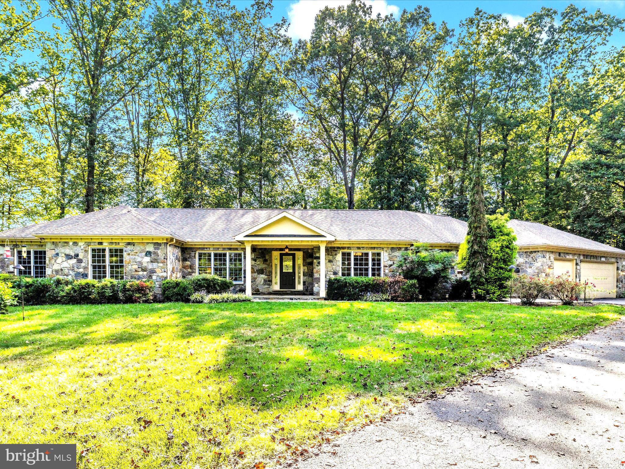 Venture through the lighted pillars and find First floor luxury living in Ijamsville. Stunning in all directions from the brand new granite countertops throughout, freshly refinished showroom floors, peacefully desirable Sherman WIlliams neutral paint throughout lives a welcoming model home like experience. Welcome home to 11589 - A Nor Ray where a first floor handicapped accessible primary suite with propane fireplace and dual walk in closets await the most discerning of buyers. Office space and four additional bedrooms with en suite bathrooms, and powder rooms for entertaining guests and 2 family rooms await. Anchoring the shared space is a field stone hearth and fireplace featuring colors of soft blues and hues of grey. From all windows and in all directions, gorgeous views of mature landscaping, flagstone sitting porches and patios and colorful trees delight. Newer appliances, under cabinetry lighting and miles of storage with a large walk in pantry hilight the kitchen amid stunning granite counters. Disposal, dual ovens, a dishwasher, microwave and cooktop with tons of counter space were designed with family and entertaining in mind! A first floor laundry with organizational cabinetry sits adjacent the kitchen close to the garage entrance, side door, coat closets and large powder room. A fully sunlit 2nd family room and wet bar allows separate space for entertaining or could be the perfect 2nd primary ensuite if ever needed. The space is wrapped in glowing windows and has access to fresh air right down to the patio and firepit. On the lower walkout level is flex office/rec space, additional bedrooms, a full bathroom and a tremendous amount of storage. On 2 acres of serene private land, you'll find this classic built stone home with incredible features and so much to offer. Beyond the long paved and sealed driveway is a lighted flag pole, a RV pad with water and electric and a gorgeous sitting porch. and There is no HOA, no covenants and a cute little chicken house with a lovely storage garage too!