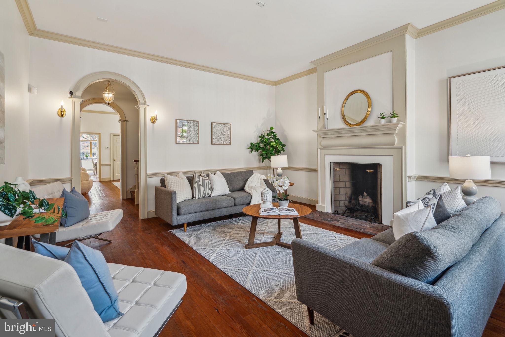 Step back in time in this stunning Society Hill historic townhouse featuring expansive interiors, four extra-large bedrooms and a grand parlor room, private outdoor space and off-street parking in one of Philadelphia's most sought-after enclaves.
Inside this more than 3500-square-foot showplace, tall ceilings soar above hardwood floors, classic double-hung windows, and handsome millwork, including crown molding, bold casings, and chair rails. The spacious living room invites you to stretch out and relax in front of the stately wood-burning fireplace. A tall archway ushers you to a gracious stair hall flanked by closets, while the oversized formal dining room sets the stage for elegant entertaining surrounded by a traditional brass chandelier and sconces. Ahead, a long butler's pantry makes hosting effortless alongside a windowed powder room. The eat-in kitchen impresses with an oversized arched window framing southern sunlight and leafy garden views, and rows of cabinet space, full-sized appliances, a built-in desk and a breakfast nook add wonderful convenience to the space.
Outdoor entertaining and lounging are irresistible in the rear walled garden featuring a brick patio, climbing vines, mature trees and views of the adjacent synagogue's gorgeous rose window. Claim this sunny south-facing space just in time for summer barbecues and enjoy off-street parking with gated access to Addison Street.
Ascend the grand staircase to discover a lovely family room/library flanked by another fireplace and a wealth of custom built-ins, including cabinetry, shelving and two large desks, perfect for studying or working from home. The palatial owner's suite on this level boasts a king-size bedroom lined with three roomy closets. In the en suite bathroom, you'll find a wide vanity, a large tub/shower, and a laundry closet, all leading to a massive walk-in closet that could easily serve as a nursery or home office. A second powder room completes this level. On the top floor, you'll find a sizeable secondary suite with a decorative fireplace, two closets and a private bathroom. Two more secondary bedrooms are joined by a windowed full bathroom and a walk-in hall closet. A large unfinished basement adds more abundant storage to this timeless residence.
Located within the Society Hill Historic District and included in the Philadelphia Register of Historic Places, this 1806 brick rowhouse is a prized example of the city's distinctive Federal architecture. From this tree-lined block, you're surrounded by glorious outdoor space, including Three Bears Park, Washington Square, Independence National Historical Park and the waterfront. Fantastic dining, nightlife, shopping and top-rated schools line the nearby streets, including ACME market on the next block. With excellent walk, bike and transit scores, this historic neighborhood is as convenient as it is beautiful.