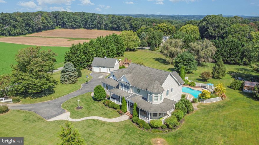 Discover the perfect blend of space and comfort in this Victorian Colonial-style home, nestled on a sprawling 2.63-acre lot with 3 car attached garage. Built in 2001, this residence boasts a timeless charming  wrap around porch with pastoral and sunset views. Step inside to find a spacious layout featuring designer moldings and turret rooms in the living room and primary bedroom. The heart of the home is the inviting family/sunroom  that flows seamlessly into the gourmet kitchen, complete with an island, upgraded countertops, and ample dining space, ideal for gatherings and everyday meals.  Enjoy cozy evenings by the gas fireplace, adorned with glass doors.  The primary suite offers a private oasis with a soaking tub, separate shower,  two vanities and walk-in closet.  The upper level has  four generous bedrooms and laundry room for convenience with access to the back staircase to main level with an additional laundry, full bath and mud room entrance to garage.  The finished lower level with rec room has walkout to patio, built in bar area, den and a full bath. Outside, the extensive hardscape and beautifully landscaped grounds create a serene retreat. Relax on the wrap-around porch or host summer gatherings by the fenced in-ground pool.  With multiple outdoor structures, including a greenhouse and stone patio and 2 zoned Invisible Fence the possibilities are endless. Parking is a breeze with a three-car attached garage and a two-car detached garage. This home is not just a residence; it’s a lifestyle waiting to be embraced. Don’t miss your chance to make it yours! New Roof was installed.