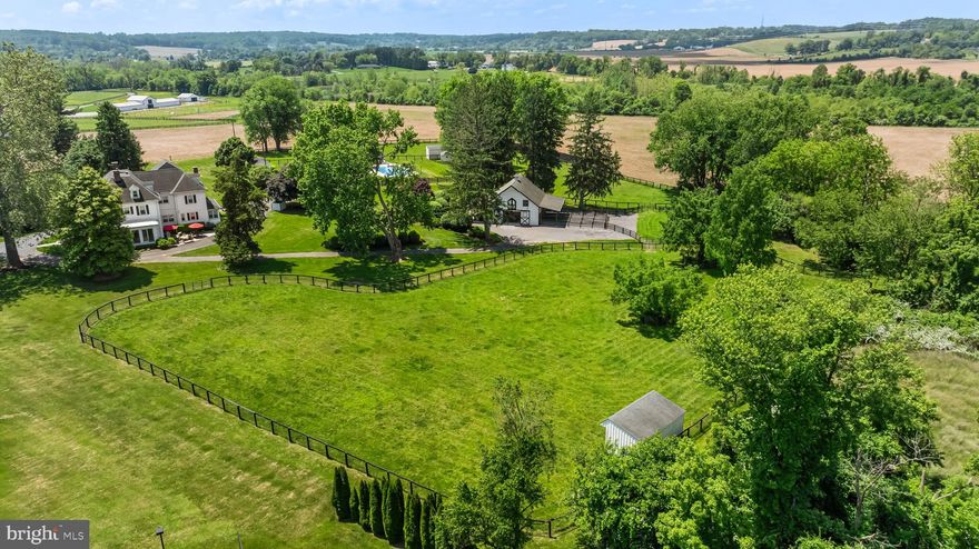 Historical charm meets modern comforts in this stately 1905 classic revival home, surrounded by picturesque farmland and less than a mile from Boordy Vineyards—with the convenience of proximity to the beltway and I-95. Inside the breathtaking entryway, you’ll find a dramatic staircase straight out of a movie set, original tiger-striped white oak floors, mahogany wainscoting, oversized coat closet, and a spacious powder room. Make yourself right at home in the newly-remodeled eat-in kitchen with commercial appliances; generous living, dining, and office spaces; main floor laundry; a cozy bar; and three of the home’s five stunning porches. Several gas fireplaces with one-of-a-kind touches and built-in shelving lend an air of warmth to the space, along with radiant heating and a highly efficient 6-zone AC. Up the grand staircase, you’ll find a sitting area, a primary suite with two closets and a brand-new bathroom with pedestal tub and separate spacious shower, a second level balcony, four additional bedrooms with window seats and large closets, and three more bathrooms. A bonus third floor is topped by a stunning skylight, one to two bedrooms and a bath, plus an additional space perfectly suited to be a playroom or game room. The basement has storage galore, a private workshop, and a 1,000-bottle wine cellar. Step outside onto your 8 acres of land (originally granted by Lord Baltimore in the 1700s), featuring a 3-stall Barn Pros stable—complete with a heated wash stall, RAMM ThuroBed mattress system, individual mud free runs, and a trio of pastures. Soak up your summers in the 50’x25’ in-ground pool, complete with a new liner and a charming pool house with its own bar. The entire lush grounds are newly landscaped and include a patio, two sheds, and the last original building on the property—a stone guest house with a bedroom, updated bathroom, and kitchenette. For family gatherings, entertaining groups of any size, or simply enjoying the unique charms of the Long Green Valley, this property is a timeless gem. Schedule your showing today!