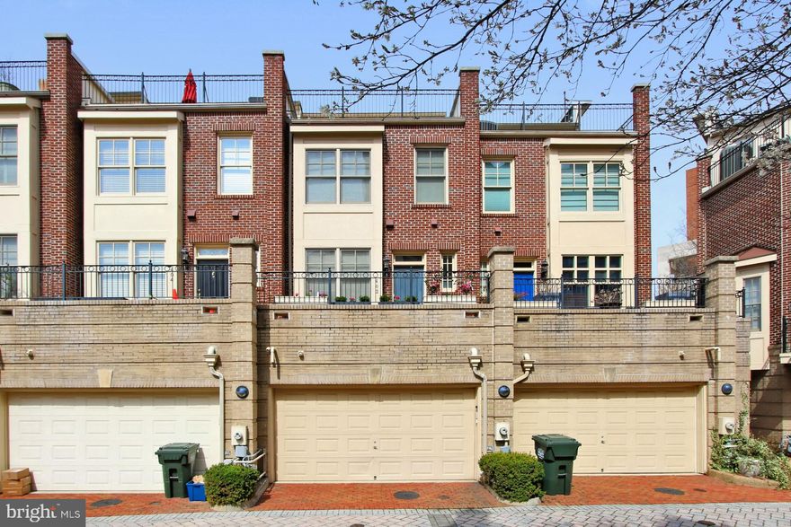 Welcome to 402 John Carlyle Street in beautiful Alexandria, Virginia! Nestled in a small enclave of upscale townhomes in the Carlyle City Residences within a courtyard setting and across from John Carlyle Park, this 3 bedroom home enjoys 3 full bathrooms and 2 half bathrooms on 4 finished levels and is loaded with unique and striking design features, including two primary suites and a ground level commercial/office space with a private entrance and powder room—rarely available in this urban Alexandria setting. A tailored brick exterior with promenade entrance, 2-car garage, an open floor plan, rooftop terrace, hardwood floors, and an abundance of windows with peaceful park views are just some of the features that make this home so unforgettable. 

Warm hardwood floors greet you in the welcoming foyer and usher you into the main living area where three floor-to-ceiling arched windows flood the space with natural light illuminating decorative moldings and a fireplace with marble surround serving as the focal point of the room. The dining area provides plenty of space for both formal and casual occasions, as chair rail and accent paint add tailored distinction. The gourmet kitchen will please the modern chef with striking granite countertops and backsplash, an abundance of 42” cabinetry, café table space, and black appliances including a Whirlpool gas range and French door refrigerator; while a pass-thru facilitates entertaining during meal preparation. A powder room with pedestal sink complements the main level.
 
Upstairs, the primary suite boasts a walk-in closet and an en suite bath with a dual-sink vanity, sumptuous soaking tub, glass-enclosed shower, and spa-toned ceramic tile—the finest in personal pampering. An additional bright and sunny bedroom enjoys access to the beautifully appointed hall bath, as a bedroom level laundry closet eases the daily task. Ascend to the uppermost level where an additional primary suite features a private full bath and sliding glass doors opening to a fabulous rooftop terrace delivering birds-eye views of the surrounding community—your own private retreat after a long day. The entrance level office or commercial space features designer textured carpeting, handicap accessible powder room, and an exterior awning just waiting for your personal touch. This versatile space can be custom tailored to meet the needs of your work and lifestyle and completes the comfort and luxury of this unique home.

All of this can be found in a courtyard setting in Old Town Alexandria, just blocks to the King Street Metro and where you’ll find some of the best shopping, dining, and entertainment choices in Northern Virginia right outside your doorstep. Take the free King Street Trolley to the waterfront and access all of the shops, restaurants Farmers Markets and entertainment that Old Town has to offer. Commuters will appreciate the convenience of nearby I-95, the Beltway I-495, Route 1, and GW Parkway. Enjoy access to an exclusive, well-maintained 25-meter lap pool or venture across the street to John Carlyle Park offering a grassy park area with benches where you can enjoy relaxing with free wi-fi and annual activities such as movie nights, a summer concert series, holiday shopping bazaar, wine festival, Alexandria Art Festival and various other events. Walk to Whole Foods, CVS, Sweet Fire Donnas, Whiskey and Oysters, Tacos and Tequila and many more restaurants. Wegmans is planned to open this Spring just a few blocks away. Outdoor enthusiasts will enjoy unlimited activities at the Potomac River, and if history, culture, and nightlife options are what you seek, Washington, DC is just a short drive away. For a unique home in an unbeatable mixed-use neighborhood, it awaits you here. Welcome home!