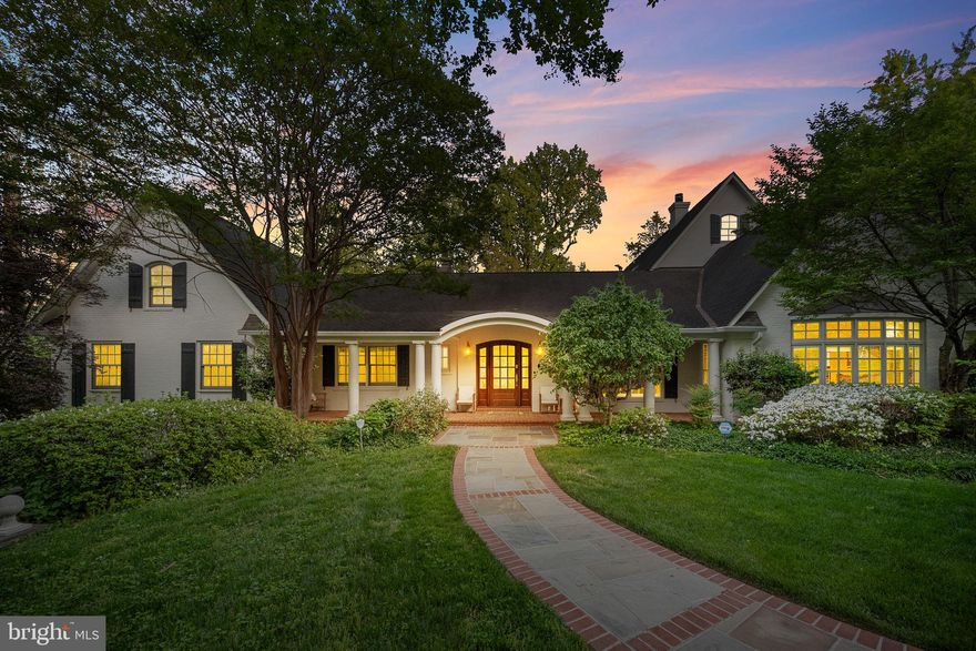 Surrounded by cherry trees on a beautifully landscaped .8-acre corner lot in coveted Rock Creek Hills, this one-of-a-kind New Orleans-inspired estate is a true showpiece where timeless elegance meets modern perfection. Arched and pillared entries, gracious covered porches, soaring two-story spaces, stunning custom woodwork, and elaborate gardens create an exceptional parklike setting complete with mature trees, flowering shrubs, and a labyrinth garden for quiet meditation. The main level is designed for sophisticated entertaining — architectural columns lead from the grand foyer to a formal living room with a gas fireplace and French doors opening to a covered porch overlooking the pool and patio, all enclosed by classic wrought-iron fencing. A formal dining room with a built-in china cabinet sits adjacent, while the dramatic two-story family room features a cathedral ceiling, twin skylights with power shades, a wood-burning fireplace, and a bay window overlooking the front yard. The chef's kitchen has been freshly updated with refinished cabinetry and features Wood Mode construction, fully integrated appliances, double-level Costa Verde granite countertops, a central work island with a separate brass sink, and a built-in sound system. The light-filled "jewel box" breakfast room overlooks the pool with two sets of French doors leading to separate covered porches. The left wing houses four spacious bedrooms — two with private en-suite baths and a hall bath serving the remaining rooms — and all bathrooms throughout the home have been fully renovated to 2026 standards with premium fixtures and contemporary finishes. An open stairway leads to a library loft with custom bookshelves and cedar closets, and beyond that, the expansive owner's suite impresses with vaulted ceilings, twin skylights, a wood-burning fireplace, a private upper-level porch, and a luxurious en-suite bath with a whirlpool tub, frameless glass shower, double vanity, heated towel rack, and a custom walk-in closet. The renovated walk-out lower level opens directly to the pool via French doors and offers a large family room with a gas fireplace, a full bath with a roll-in shower, an artist's studio, and a second full kitchen. The freshly serviced pool area is resort-worthy, featuring a Hot Springs "Prodigy" hot tub, Weber natural gas grill, spacious pool deck with fire pit area, and a spectacular wrought-iron enclosed patio. The entire interior and exterior of the home has been freshly painted, and the home boasts 59 solar panels, three separate HVAC zones, under-floor radiant heat in the kitchen and family room, and a high-capacity natural gas generator. A driveway with a turnaround provides ample parking, and the location is unbeatable — just one block to Beach Drive and Rock Creek Park trails, and minutes to downtown Kensington, Bethesda, and Friendship Heights.