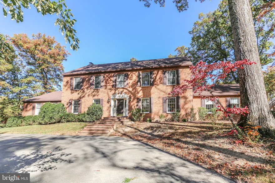 Incredible opportunity on this 4,300 sf all brick Colonial on over 3.5 acres in a prime Woodbridge location. This stately home sits on 2 acres with an adjoining 1.53 acre lot included in the sale.  Keep the additional lot or potentially build another home.  Located just minutes off of I-95 but tucked in a quiet, mature trees and wooded community. 
In the same family since 1995, this home is ready for new stewards to reenergize the wonderful  amenities including an indoor pool, outdoor tennis court, numerous outbuildings, and over 1,500 sf of decking with 2 ramps.  With the location at the end of the culdesac and up a treed entrance, privacy abounds as you curve around the paved circular driveway and additional parking in front of the 2 car side attached load garage.  Check out the floor plans in the pictures to see the amazing room sizes of the main floor with over 2,300 sf of living space to create a fantastic opportunity for entertaining. The 32x27 great room off the kitchen with a wet bar leads out to the indoor pool area. The second floor boasts 4 bedrooms that includes a spacious Primary Suite, 2 with a "jack and jill" full bath and another 20x15 Bedroom with ensuite full bath and full walk up stairs to a finished 3rd floor 27x13 flex space and an unfinished 23x22 storage area that houses 2 of the 3 Brand New HVAC units.  The tall 2 story side load garage houses the 3rd new hvac unit and has great storage closets and work benches. Check out all of the pictures for the plat and floor plans as well.