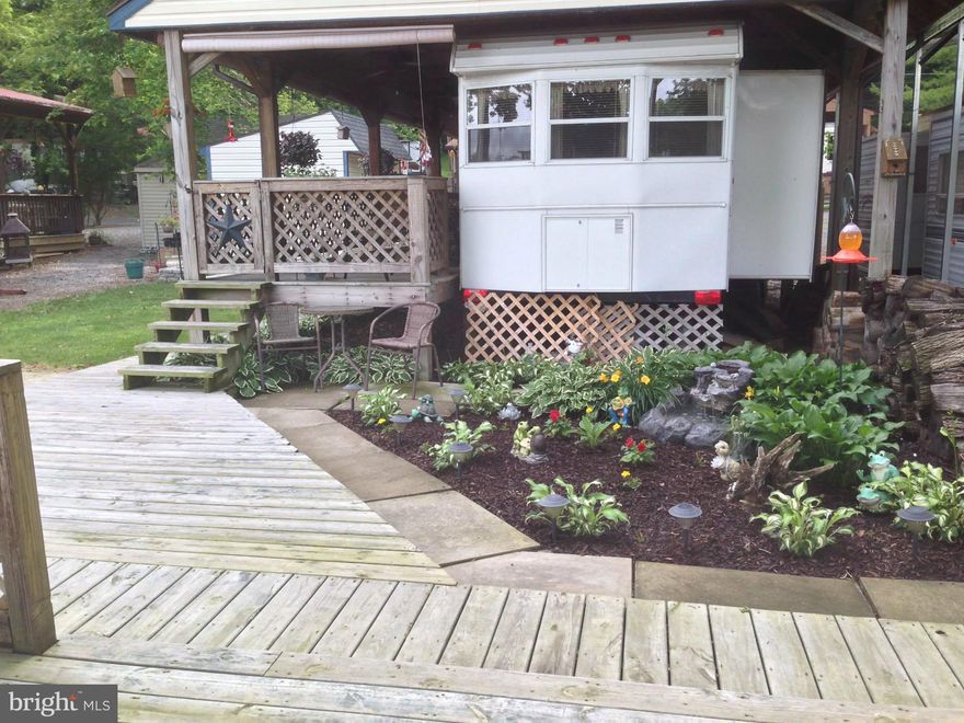 Experience the serenity of waterfront living with this remarkable property, which includes a stunning 2007 Hi Line Custom Park Model Camper. This meticulously maintained camper boasts a spacious home refrigerator and a cozy electric fireplace, making it the perfect retreat. You’ll find everything you need right here to embrace the idyllic river lifestyle—just bring your personal belongings and settle in!

Included with this wonderful lot is a vintage 1997 Yamaha golf cart, ideal for leisurely rides along the water. Have fun on the water with the 2013 Sweet Water 22' pontoon boat, equipped with a powerful 70 hp Yamaha motor. Enjoy easy access to the river with your private boat dock and ramp and transport your boat effortlessly using the included trailer. 

The shed is a treasure trove of supplies, packed with essentials such as water floats and river mats—think of it as your very own mini-Home Depot. 

Step outside onto the expansive deck that overlooks the glistening river, complete with electrical outlets and comfortable seating that conveys with the property. The enchanting yard features a charming fire pit for cozy gatherings and a tranquil water feature adorned with perennial plants, adding to the beauty of your outdoor space. Sunshades provide respite from the sun on the deck, where you’ll find a gas grill and a flat griddle, perfect for outdoor cooking and entertaining.  Dues for this lot are paid in full and will not be prorated at closing! Don't miss this TURNKEY lot opportunity.

This rare opportunity to own a piece of paradise at the river awaits you! Don’t hesitate—schedule your appointment today and start your adventure in waterfront living.
This is a gated community, so you need to enter at the guard shack. Entry is not permitted without ID per the office rules. Bring IDs to the office or guard shack for visitor pass. THIS IS A SEASONAL CAMPGROUND! OPEN FROM APRIL 1 TO NOVEMBER 1. This lot is conveniently located for walking to the swimming pools, restaurant/lounge, mini golf, youth center, playgrounds and more. Large lot to enjoy time with your family & friends. River Bend is a privately owned 400 acre recreational- vehicle camp resort with seasonal activities for members, families and guests. Less than a 2-hour drive from the Washington and Baltimore metro area. Open with utilities from April 1 to November 1. Lot owners have access to their property the entire year. *** Members Enjoy *** * Amazing views and wildlife, Potomac River access, Trails, Swimming pools, Mini-Golf, Youth center, Tennis and basketball courts, laundry facilities, convenience store, deli and lounge. *Bath houses throughout the park, boat ramp, bar and grill and even a church located on the grounds. River Bend also hosts numerous activities such as 4th of July fireworks, small carnival, bonfires, poker runs, horseshoe tournaments, car show, Halloween Trick or Treat and so much more. The river is deep water for swimming, tubing and water skiing. CAN NOT LIVE HERE YEAR ROUND.