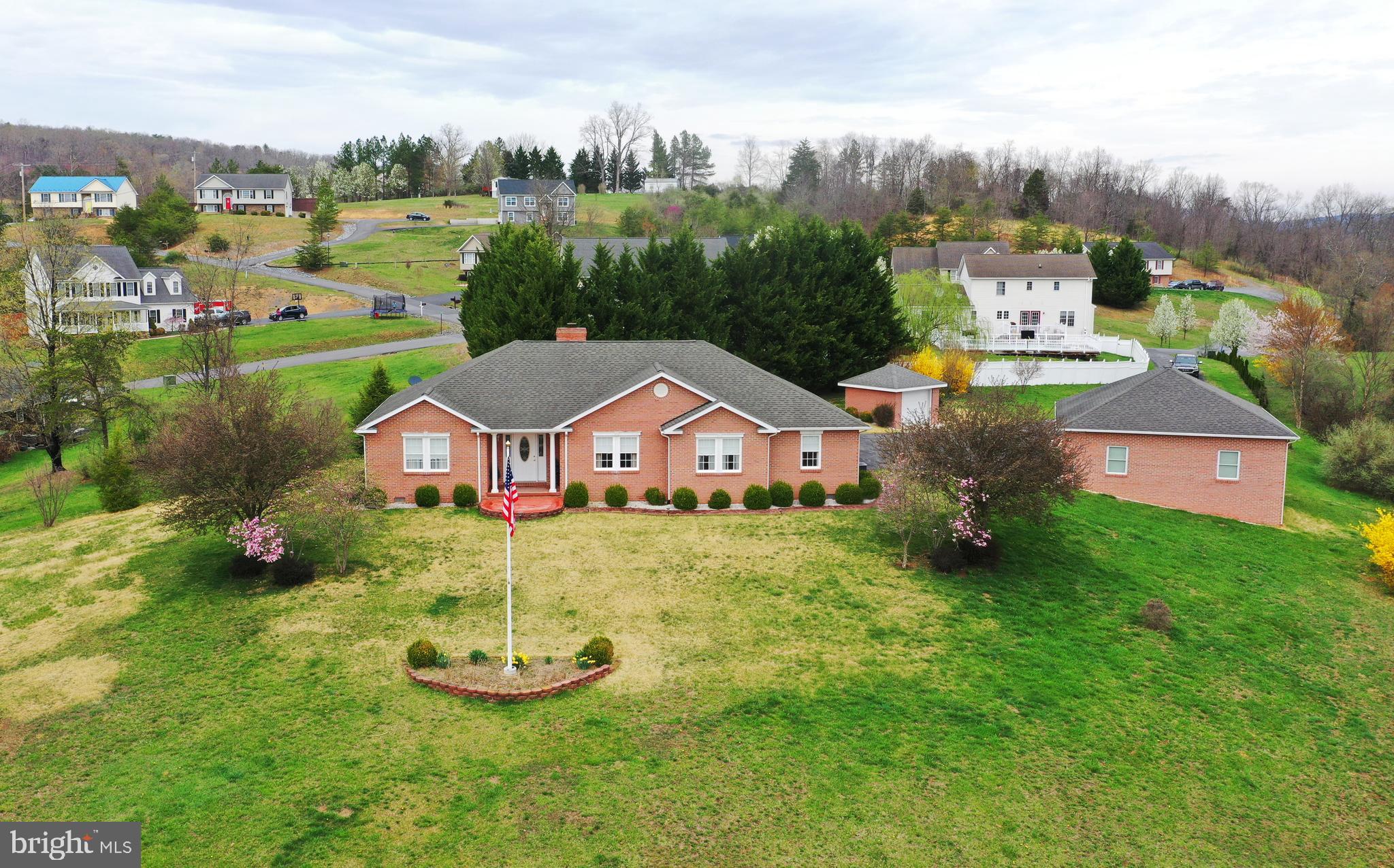 SCENIC VIEWS AND RIVER ACCESS. THIS MAJESTIC ALL-BRICK RANCHER OVERLOOKS MOUNTAINS AND THE PICTURESQUE TOWN OF CAPON BRIDGE. Well-maintained, one-owner home that a builder built for himself. Car enthusiasts and hobbyists will love the attached and detached garages and garden shed. On nearly 2 acres in Water View Estates, a community of lovely homes. More than 2,000 square feet of living area, all on one level, with 3 bedrooms and 2 baths. Elegant hardwood and tile floors, pillars and chair rail. Wood-burning fireplace with an insert and custom-built mantle. Well-appointed kitchen with custom-crafted Elwood McIntire cabinets. Formal dining room and a private study. Primary bedroom suite offers double closets and a bath with a walk-in shower, jetted tub, grab bars and built-in cabinets. Large laundry room with cabinets, desk and closet. The great room's impressive entertainment center conveys. Porches, patios, a brick walkway and lovely landscaping grace the outdoors. Paved driveway with large parking area. Newer HVAC and refrigerator.