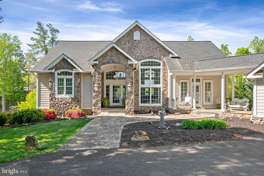 Resort style waterfront living at Lake Anna! This gorgeous lake home is tucked away on the beautiful shoreline of the public side.  Gated and paved driveway.  Located in a cul-de-sac, this magnificent 5 bd/3.5 ba home is gorgeously constructed of stone and hardiplank. The two car detached garage is the perfect spot for all your lake toys and is connected to the house by a breezeway.  As you enter the foyer,  you will feel right at home in the comfortable and stylish great room with vaulted ceilings, massive palladium windows and three sets of French doors showcasing your BREATHTAKING water view! Enjoy main level living with the primary bedroom located on the main floor, complete with MORE water views, an en-suite bath and a massive walk-in closet. The gourmet kitchen includes stainless steel appliances, gas cooking, a HUGE island with seating, granite countertops, and plenty of cabinet space. Gorgeous stonework, a cozy gas fireplace for those chilly nights, and maple hardwood floors are just a few of the features you will notice as you walk through this 3800 square foot home. When you are ready to enjoy the night air, step out onto the deck made of exotic imported hardwood to enjoy the spectacular Lake Anna sunsets. The lower level features an additional four bedrooms, two full baths, a kitchenette, family room and lots of storage space. A paved trail will lead you to your very own waterfront oasis with 100' of shoreline and deeper water for boating and swimming. Featuring a boathouse with maintenance free decking, two boat slips (one is a heavy hoist), two jet ski lifts, two storage areas and a floating sundeck, you will love the outside of this home as much as you love the inside! Close to restaurants and shopping by land or lake.  High speed Xfinity is available!  Short term rentals allowed.