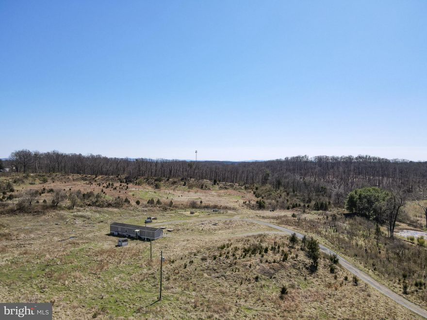 This unrestricted 22-acre parcel presents a prime development opportunity, ideally located just minutes from I-81 and perfectly positioned between Spring Mills and Martinsburg, WV. The existing home is serviced by a well and septic, with nearby access to public utilities.