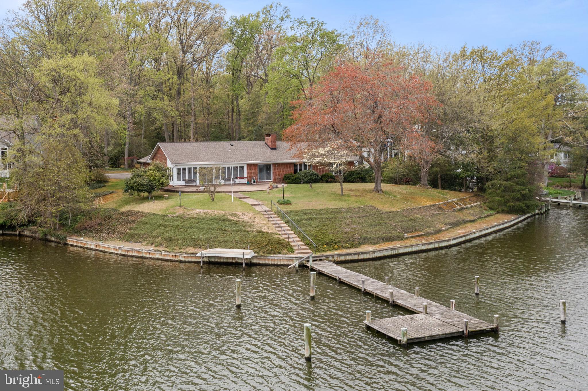For comp purposes, the closed sales price does not reflect an additional $1,00,000.00 incentive offered to the seller from the buyer. Therefore the total closed price is $2,100,000.00.
Wonderful opportunity in Amberley. Built in 1978, this handsome well-built brick rancher on Whitehall Creek is being offered for sale for the first time. The 3 bedroom 2.5 bath home is located on an acre of land with 250 feet of water frontage, a pier, 2 deep water slips, and 6-8 ft of MLW. The home has approximately 3663 finished square footage, which does not include the lovely waterside screened porch. It also has a partially finished basement with outdoor access, windows, a wood-burning fireplace, and a workshop. The total sq footage is 4576. The home offers hardwood floors throughout, a formal dining room, a living room, a cozy beamed ceiling family room with a stone-faced wood-burning fireplace, a kitchen, a mudroom, and a large attached 2-car garage, The seller replaced the roof in 2018 and the HVAC in 2021. Renovate and make this your dream home! Amberley is a water-privileged community. The neighborhood is one way in and one way out with a 2-mile Holly Drive loop, great for kids, bikes, and dog walking. There are 188 homes and 3 community piers with 45 deep water slips located on Ridout and Whitehall Creeks. Located off Rt 50 it is an easy commute to DC, Baltimore, and the Eastern Shore.