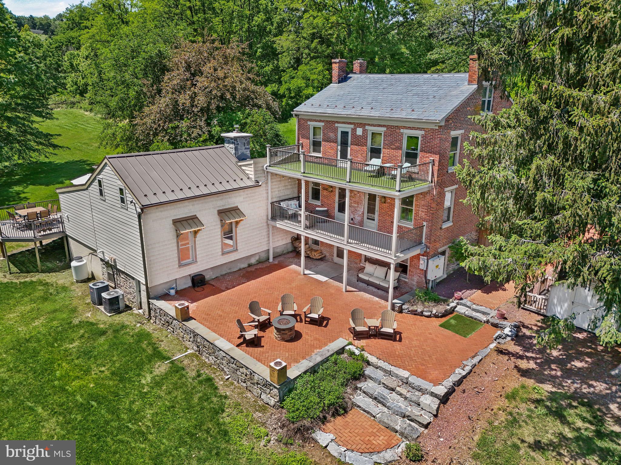 Welcome to 154 Calvary Church Road, where timeless craftsmanship meets curated living on 6.69 private acres. This truly exceptional estate is fully reimagined, blending timeless 1860s farmhouse charm with magazine-worthy modern upgrades—crafted not for resale, but for legacy living. Tucked away on nearly 7 private acres of land, with a bank barn, pond with fountain, multi-level veranda overlooking a brick courtyard, and low maintenance landscaping, this one-of-a-kind residence is both a dream home and a legacy in the making.
Originally constructed circa 1864, this fully transformed farmhouse compound is more than a home—it’s a lifestyle canvas for the visionary. Whether you're seeking a multigenerational haven, space to homeschool and grow, a holistic lifestyle rooted in the land, or simply a forever dream home that stuns at every turn—this property delivers.
The layout provides flexibility: offering the option to live as one cohesive, expansive residence, or to utilize the original farmhouse wing—complete with its own entrance, 3 bedrooms, 1.5 baths, and a converted kitchenette—for guests, extended family, or optional Airbnb use. And yet, it all flows beautifully as a single home, with gathering spaces and quiet corners thoughtfully woven throughout.
At the heart of the home, a show-stopping designer kitchen—the kind you'd expect to see in Architectural Digest—anchors the living space with a dramatic stone fireplace, custom cabinetry, pot filler, skylight, and an abundance of counter space designed for both daily life and unforgettable moments.
The primary suite is a retreat in every sense: featuring an exposed original stone wall, wood stove, coffee bar, and soundproofed shiplap ceiling, with direct access to the brick patio overlooking the side yard and pond.
Just a few steps up, a one-of-a-kind bedroom showcases a wall of windows, lofted bonus space, hanging swing chairs, an ensuite bath, and a second laundry area—ideal for older children, guests, or creative use. Every bathroom has been completely remodeled, and each finish reflects a harmony of modern luxury and timeless design.
The list of improvements is as intentional as it is impressive: a mahogany double-door entry, high-efficiency Low-E windows, three central vacuum systems, UV air purification, a fully reimagined mudroom and pantry wing, drainage enhancements, brickwork restoration, and extensive soundproofing in the lower level. Even the historic bank barn was reimagined with fresh paint, and an oversized RV bay with a poured concrete floor— offering the potential to convert into anything from a workshop to an event space.
Every inch of this property has been meticulously curated with intention, offering the rare opportunity to live in a home where history, design, and future potential all align. The only thing missing is the next owner who will love it as deeply as it was built to be loved—nestled in a setting that offers privacy without isolation, where you're just minutes from daily essentials, yet surrounded by quiet, sky, and open space.