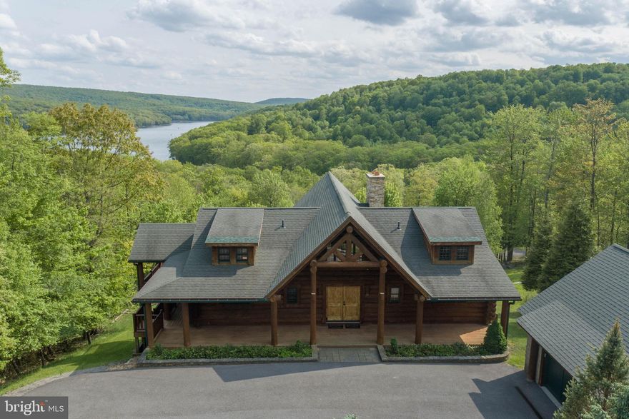 Nestled between rolling mountains boasting dramatic views of Deep Creek Lake and the Appalachian Mountain range, you have found your log home lodge escape.  Write the next chapter of your life from this custom log home lodge with sweeping four-season views from pretty much every room, patio, and balcony.  Open floor plan, four bedrooms with two primary suites, vaulted ceilings, two stone wood burning fireplaces, detached garage, and has never been rented.