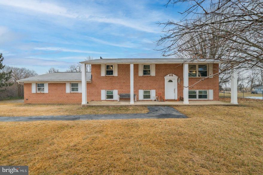 Offered for sale is this charming brick split-foyer home located just outside of historic downtown Charles Town, WV! This home is situated on a level 1.56-acre lot with expansive farm views in both the front and back, and the best part is that it has no HOA! The home has undergone numerous recent renovations, including the bathrooms and kitchen, fresh paint, hardwood flooring in the upper-level main living areas, and new LVP flooring in the basement. The owners are also in the process of replacing the flooring in all bedrooms. The current pictures do not reflect that, but they will be updated when completed. The upper-level kitchen is highlighted by a gorgeous ceramic-tile backsplash, stainless-steel appliances, and soft-close cabinets. The dining room features a custom-built booth and a large bay window that provides an amazing view while dining. Beautiful hardwood floors extend through the dining and living rooms and down the hallway. Also at this level, you will find two bedrooms, an office, a full bath, and an additional half bath in the primary. The lower level provides two additional bedrooms, a 2nd kitchen, and a living room with a wood-burning fireplace insert. This lower level would be ideal for an in-law suite or a potential separate rental unit. The laundry room is on the lower level and can also be accessed through the garage or an exterior door to the backyard, making it convenient for shared laundry use if the lower level is rented. The fenced backyard is great for children and pets, and the large rear deck is perfect for entertaining guests or relaxing and taking in the property's amazing views. Some exterior photos have been digitally enhanced to remove patches of snow.  Schedule a private showing today to see for yourself everything this property has to offer!