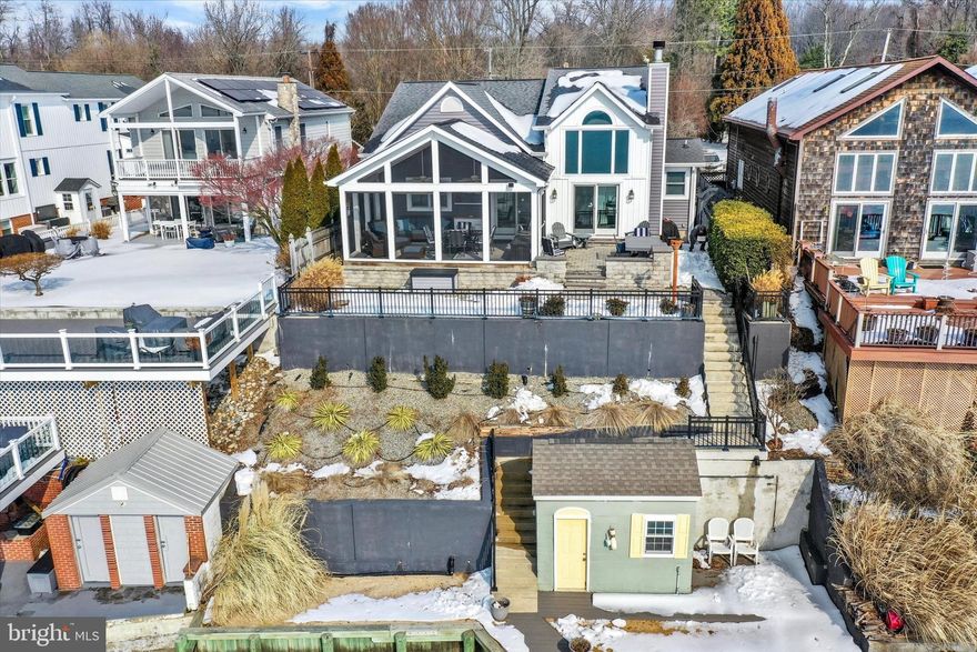 Waterfront Living at Its Finest in Rocky Point! Enjoy wide open water views and breathtaking sunsets in the highly sought-after Rocky Point area. Ideally located for both boaters and land lovers, enjoy easy cruising to Hart-Miller Island, Pleasure Island, and multiple waterfront dining destinations, while Rocky Point Golf Course and Essex Skypark are just minutes away. With 50’ of waterfront, 4’ mean water, sandy bottom and direct boating access to the Chesapeake Bay, this fully renovated 3-bedroom, 1.5-bath home delivers the ultimate Upper Bay lifestyle, complete with a rare basement and no flood insurance required. The outdoor setting is exceptional! A 120’ pier with new decking and a 30’ x 10’ T-head offers electric and water service, an 8,000 lb. boat lift with remote, jet ski lift, pier storage shed and dock boxes conveying. A sandy beach area, Trex walkway, new bulkhead, and poured concrete retaining walls create a waterfront footprint designed for entertaining, relaxing, and maximizing time on the water.   Inside, the open-concept main level is designed for both everyday comfort and hosting. Porcelain tile floors and solid wood doors run throughout. The living room features a pellet stove with granite hearth, a dramatic two-story section with vaulted ceiling and a massive picture window framing the water from the main living areas and loft. Sliders lead to the paver patio and stunning screened porch with cathedral beadboard ceiling, seamlessly extending your living space outdoors. The fully remodeled gourmet kitchen offers white shaker cabinetry, granite countertops, stainless steel appliances, 5-burner gas range, under-cabinet lighting, tile backsplash, breakfast bar seating, great table space  and a large window over the sink to capture the view. The adjoining dining area with vaulted cedar ceiling easily accommodates gatherings large and small, while a dedicated office with custom built-ins and bay window provides versatile space. Two spacious bedrooms and dual-entry full bath with jetted tub/shower combination are located on the main level. Upstairs, a private third bedroom with vaulted ceiling is complemented by an open loft overlooking the living room and capturing elevated water views — ideal for guests, lounge space, or potential fourth bedroom. The street side of the home is equally impressive with a raised roofline, architectural shingle roof, updated siding with board & batten accents, covered front porch, custom garden shed with electric, oversized detached garage with workshop, electric and 240v outlet, white vinyl and privacy fencing, and parking space for 4–5 vehicles. Additional updates include HVAC with propane backup, multiple water heaters (including tankless for the jetted tub), encapsulated crawl spaces, and a full lower level with HardiePlank walls, speckled polyurethane flooring and abundant storage with great laundry area and workshop space, washer/dryer and shelving convey. Ideally positioned for both waterfront living and everyday convenience, with quick access to major commuter routes, Baltimore, and BWI. MOVE IN NOW AND BE SETTLED IN TIME TO ENJOY SPRING AND SUMMER ON THE WATER! **See the full list of updates that have been completed over the last 11 years** WELCOME HOME!