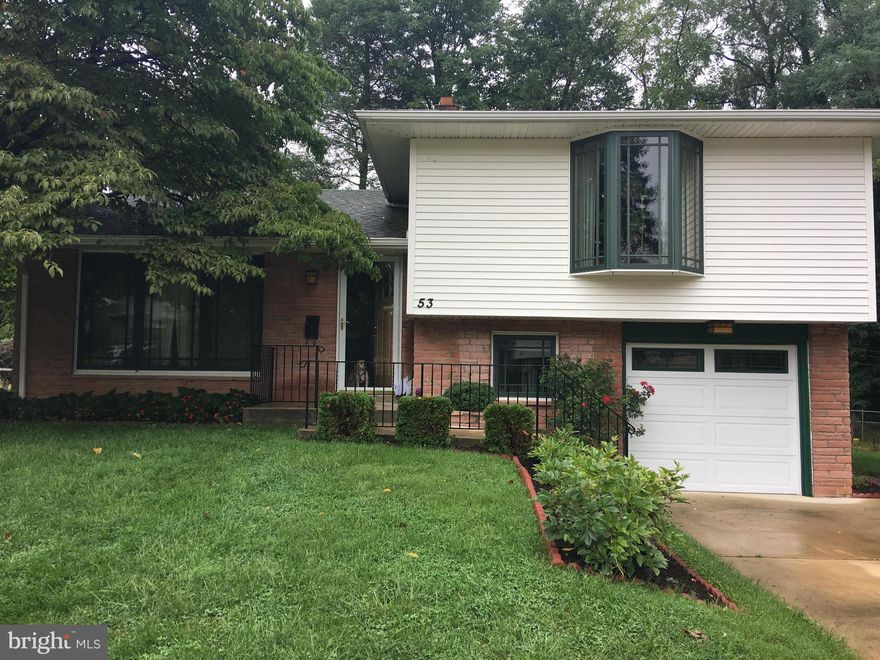 Enter this beautiful split-level home into an enormous open concept living room-dining room space with meticulously refinished hardwood floors, giant picture windows in both the living and dining rooms with natural wood divided light accents that look out on front and back lawns. The kitchen continues the natural wood theme with lots of cabinetry and also includes a four-burner gas range and exhaust hood; and ample space to work. Descending down the steps from the kitchen is a stunning family room with custom built-ins, sliding glass doors providing access out onto the private patio for entertaining and a  view of the woodlands behind the house. This area has a niche that can be used as an office easily. A full bath as well as access to the one car garage can also be found on this level. Another level down is a flexible space that can be used as a theater room, exercise room or gigantic office boasting more built-in shelving, a built-in Bose sound system and closet space. The other half of the basement level houses the tankless hot water heater, washer/dryer and clean dry storage. The hardwood floors from the living room continue up the stairs to three generously sized bedrooms. The bedrooms offer gigantic windows that flood the rooms with light as well as ample closet space. The front and back bedrooms boast bay windows with French casements that feel like miny solariums. This floor includes another full bath with a deep soaking tub. The property backs up to a local park and includes a ground level shed for extra storage.