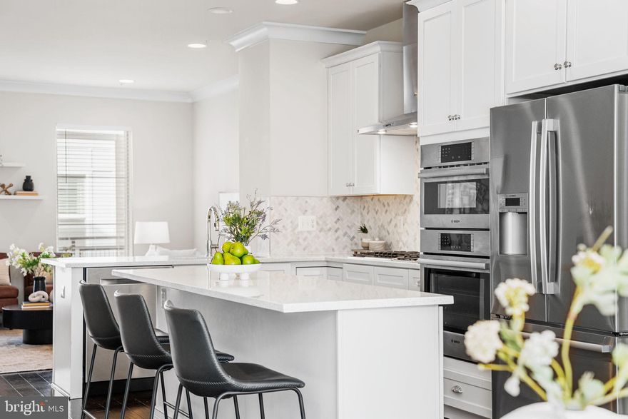 Built in 2020 and offering over 1,900 square feet across four thoughtfully finished levels, The Lakeside Crossing Residence delivers modern design, flexible living spaces, and standout outdoor living in Chantilly. The entry level features a spacious recreation room ideal for a media lounge, home gym, or guest retreat, with direct access to the one-car garage. The main living level is anchored by a gourmet kitchen with quartz countertops, gas cooktop, wall oven, stainless steel appliances, center island, and abundant counter space, flowing seamlessly into a separate dining area and a bright living room with a Juliet balcony and excellent natural light. A convenient half bath completes this level. The third floor offers a primary suite with a dual-sink bathroom and generous closet space, along with a second bedroom featuring its own private full bath. The top level includes a third private bedroom with a full bathroom, a versatile loft ideal for a home office or additional living space, and a beautifully designed rooftop terrace perfect for entertaining, relaxing, or enjoying open-sky views. Located moments from Wegmans at Westfields, Burn Boot Camp, Lazy Dog Restaurant & Bar, CAVA, Sedona Taphouse, Mellow Mushroom, and nearby coffee shops, with easy access to Route 28, Route 50, I-66, Dulles Airport, and the Dulles Tech Corridor, this home offers exceptional lifestyle and commuter convenience.