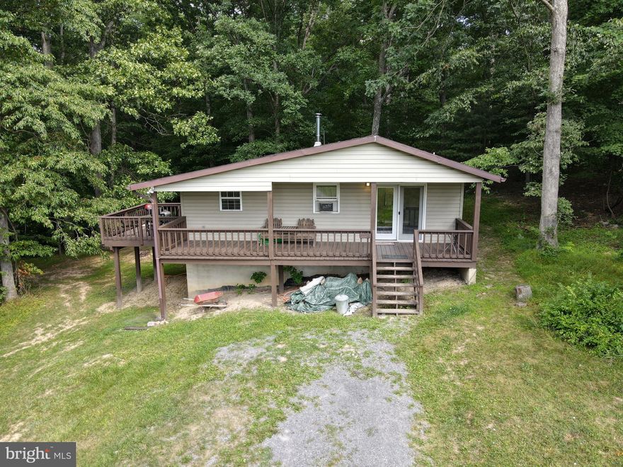 Nice 3 bedroom,  1 bath cabin in Great Cacapon sitting on 2.44 acres.  Property features it's own pond and local public river access is about 1/2 mile away.  Nice interior features are a wood stove, sliding door to a balcony, and partially finished basement space.  Nice covered front porch and skylights to let in a lot of natural light are also nice features.  Nice big yard for plenty of activities.  a must see!