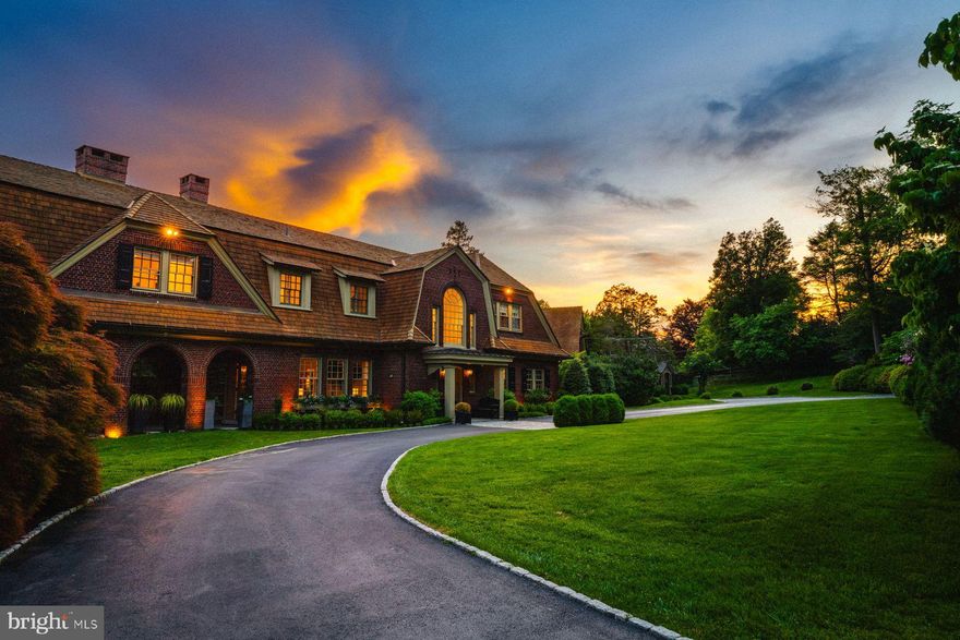 Perched on the Morris Arboretum, 9410 Meadowbrook Avenue epitomizes timeless elegance and expert craftsmanship. Originally built in 1912, this home has been meticulously revitalized by blending historic charm with modern allure. Treat yourself to a tour of modern spaces on three levels, and outdoor spaces with a pool designed for fun and relaxation. Designed by architects Walter T. Karcher & Livingston Smith, the Dutch Colonial Revival exterior gives way to a beautifully restored interior, boasting exquisite moldings and millwork, tall windows, pillars and pilasters, and handcrafted fireplace mantles against a backdrop of wonderful oak floors with inlays. Enter the home into the wide front to back center hall, which provides a welcoming foyer leading to a seamlessly flowing floor plan. The formal living room, featuring a fireplace, transitions smoothly into a cozy library with built-in bookshelves and a charming window-bench seat. An arched veranda and patio extend the living space outdoors off the library, perfect for gatherings and enjoying the fresh air. The elegant dining room, with its fireplace and banquette area, sets the stage for refined entertaining. The adjacent kitchen is equipped with Viking, Sub-Zero, and Bosch appliances and is complemented by a walk in pantry as well as a butler's pantry with bar sink, wine chiller, dishwasher and ample storage. Off the kitchen, there is a spacious vaulted family room with fireplace, powder room, and mudroom, completed by two tall sliding doors that give access to the outdoor kitchen and built in firepit. Upstairs hosts five bedrooms and four baths, offering peaceful retreats for relaxation. The primary suite includes a private balcony, a serene window seat, and a luxurious marble bath with a freestanding soaking tub and spacious shower. Additional bedrooms provide versatile accommodations, while a loft offers a charming reading nook overlooking the great room below. Recreation abounds within the lower levels, where a squash court awaits enthusiasts and a gym with sauna invites rejuvenation. A media/gaming area, fully outfitted wet bar, and original vault repurposed as a wine room cater to leisurely pursuits, while the sprawling grounds outside calls with a saltwater pool tucked within the gardens, offering a tranquil oasis for relaxation. Distinguished by its inherent grace and impeccable restoration, 9410 Meadowbrook Avenue stands as a testament to enduring sophistication and refined living, poised to embrace the next century with timeless elegance and unrivaled splendor.