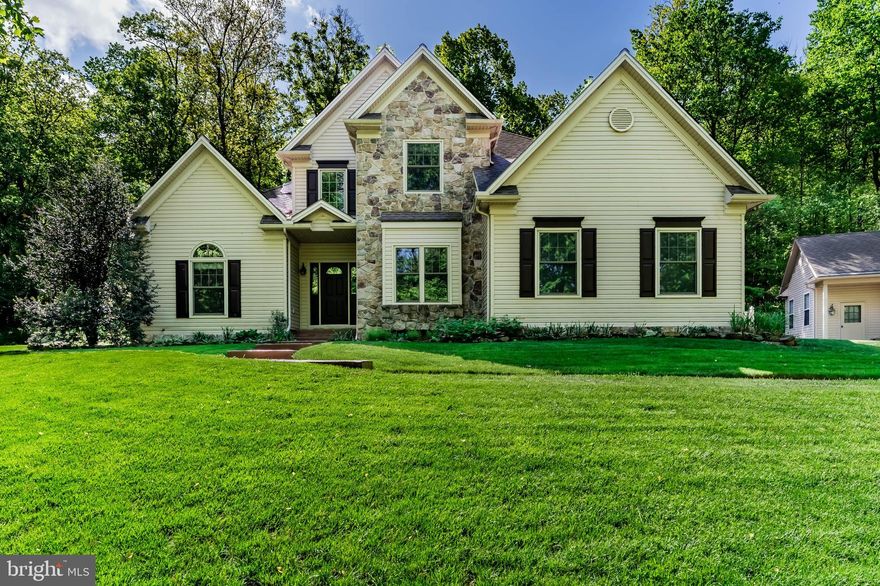 Welcome home to your private wooded paradise! This Jim Miller custom built, one-owner home is situated on 8.74 acres and radiates pride of ownership from every angle. Nestled in an entirely wooded setting with seasonal views of Ski Roundtop, this exceptional 5 bedroom, 3.5 bath home offers a perfect blend of craftmanship and comfort. The main level impresses with nine foot ceilings, with a primary suite featuring elegant tray ceilings and a cozy gas fireplace. The heart of the home - a gorgeous kitchen with granite counters, an eating bar and custom lace wood mahogany cabinetry - flows seamlessly into the 18’ cathedral ceiling family room, anchored by a striking stone floor to ceiling wood burning fireplace. You will also find the laundry room on the main level.  Upstairs you will find 3 generously sized bedrooms with a full bath and walk-in attic for additional storage. The lower level delivers even more living space with a massive game room, 5th bedroom, flexible office/workout room and another full bath. Energy efficient geothermal heating and cooling along with a tankless water heater keeps you comfortable year round, complemented by a back-up generator. Entire home also has new Window Nation windows with transferrable warranty, installed in 2024. Outside, the entertainment possibilities are endless. A beautifully designed patio by Hively Landscapes features built-in gas grill, fire pit, fish pond with waterfall and lighting, and stamped concrete walkways. A detached 3 car garage with carport, woodshop and greenhouse rounds out the property. Enjoy your own half mile walking trail along the perimeter along with a play area with swing and rubber mulch in the back yard. Located in the much sought after Northeastern school district.  Schedule your private showing today!