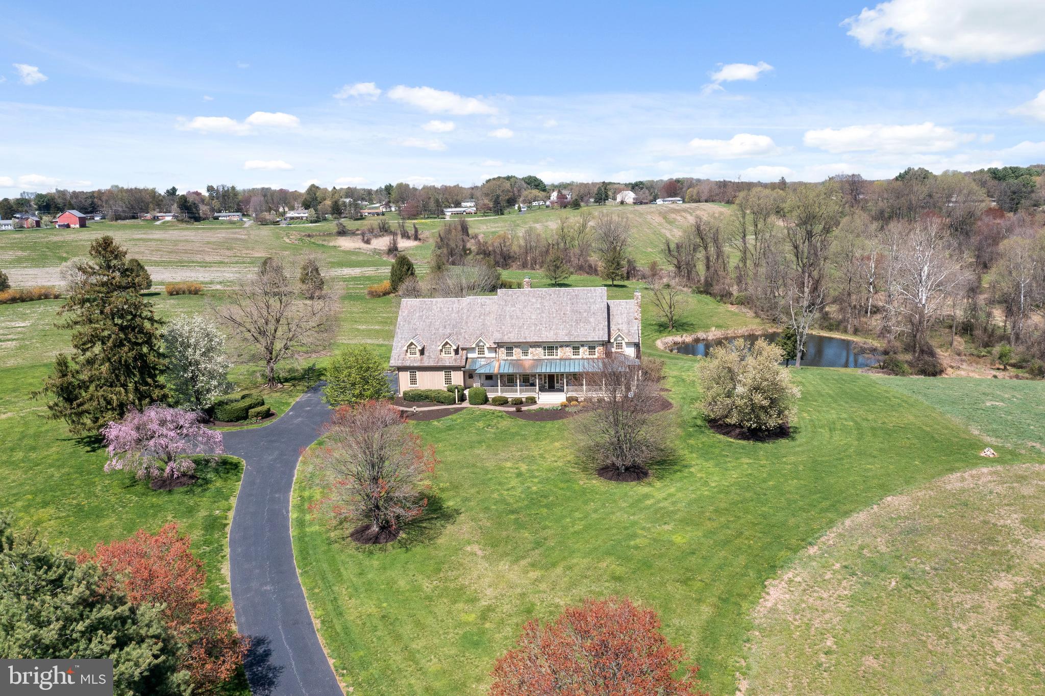 This Custom Built Farmhouse has combined the architectural integrity and charm of history and tradition while providing every possible modern amenity. The five bedroom, three and a half bath home is on 45 acres with uninterrupted views of the countryside. Wonderful open floor plan and spacious rooms are perfect for entertaining with great detail throughout the farmhouse highlighting extensive stonework, millwork and random width hard pine flooring. Entertain in a gourmet kitchen with an island and stone fireplace, which is open to a large breakfast area and the family room with a fireplace and wood beams. French doors access a large deck with stunning views of the spring-fed pond and open space. Off the family room is a sun-filled sitting room and a library/music room with an additional fireplace and French doors opening to the wrap-around front porch. Relax on the front porch and enjoy views of the 222-acre Peacedale Preserve. Completing the first floor is a living room, dining room off the kitchen and large mudroom with laundry. The second floor has a large primary bedroom with a sitting room and large full bath. Enjoy morning coffee on your own deck with a view of the pond! Three additional bedrooms, one en-suite complete the second floor. Walk-out basement waiting to be finished with access to the oversized 3+car garage! NEW Cedar Shake Roof in 2021! Circa 1800 stone barn is perfect for an art studio, gym, home office or party barn!! Endless possibilities!!! Great property for horses with a lot of open land for an additional barn and paddocks. Land is currently being farmed. Property has Subdivision Potential! This is a great location!! Close proximity to Delaware and Maryland borders, University of Delaware and the Fair Hill Equestrian Center!!