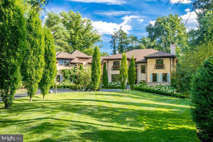 Nestled on over 1.5 mature acres rests this custom-built 5 bedroom 6.2 bath Tuscan dream estate with modern upgrades galore. Tucked at the end of a circular drive sits the gracious main house with 3-car garage & a high-quality attached wing with secondary garage accessible by stairs, 2nd floor hallway or elevator ? perfect for a private home office, in-law suite, or adult child apartment. Beautifully appointed interiors are bathed in natural light, with no detail overlooked. From the grand entry with sweeping iron staircase to the elegant den with fireplace & chef?s kitchen with family room, no detail is left unturned. Gorgeous hardwoods, exposed beams, oversized windows, designer lighting & natural stone accents create a warm ambience built to entertain. At the heart is a gourmet kitchen with top-of-the-line built-in Sub-Zero & Wolf appliances, custom Kraft cabinetry & heated tile floors. A walk-in pantry, hidden flex space & massive island with breakfast bar take it over the top. Enjoy morning coffee in the sunny breakfast nook, wrapped in picture windows overlooking the grounds. Nearby, make memories in the family room around the stone fireplace flanked by walls of windows. Host a dinner party with ease in the formal dining with service bar, or connect with nature on one of several entertaining decks, including a covered veranda surrounded by grassy lawn & expansive wood deck with outdoor lounge & fireplace. Back inside, your generous master suite awaits with a cozy gas fireplace, Juliet balcony & his/her custom closets. The spa-like bath has dual vanities, rain shower & deep soaking tub. Down the hall is a full laundry room & 4 guest bedrooms, all en-suite with spacious closets. Among many thoughtful touches & upgrades is an elevator with handicap ramp access, day-lit home gym, craft room, art studio, handsome study, finished dry basement, custom crafted corbels & mantels, dramatic arched hallways & rounded drywall corners. The state-of-the-art wireless 10-zone Sonos home audio system lets you play any song in any room from your iPhone app. You can use it as an alarm clock or to put yourself to sleep. This is complemented by 5 remote-controlled gas fireplaces + abundant secluded storage. This fully geothermal home also affords very low utility bills, a whole-home backup generator, no exterior wood allowing for zero future maintenance, plus 40 years remaining on the roof warranty & nearly 10 left on the windows. The storm water system is another bonus, as heavy rainwater drains into underground pits, so no surface water flooding. With space to park 4 cars, the main garage is equipped with a 220 amp Tesla charging station & courtyard that doubles as a half-court basketball court. Front driveway can be used as a lacrosse catch or baseball practice area for kids. Out back, the entire family will love taking the stone steps down the hill to a quiet brook that serves as a safe place for kids to roam & play, then come wash up in the mud room. Ideally located in walking distance to the Village of Gladwyne, with scenic Bridlewild hiking trails steps from your door & 87-acre Kenealy Nature Park close by, this home has it all.