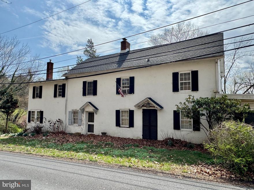 Truly one-of-a-kind, this character-filled large stone farmhouse dates back to the 1800s and sits on a rare double lot in a peaceful, scenic location. Brimming with old-world charm, the home offers a blend of unique historic details and spacious living. The first floor welcomes you with a formal living room, a striking kitchen featuring cathedral ceilings and exposed beams, a generous family room with a stunning fieldstone fireplace, a formal dining room perfect for entertaining, and a bedroom with a private bath. Hardwood floors run throughout the home, adding warmth and timeless appeal. Upstairs, the second floor features a spacious main bedroom with vaulted ceilings, along with three additional well-sized bedrooms. The third floor is a true bonus, offering two more bedrooms and a cozy sitting room between them — an ideal retreat or creative space. Located on a quiet road with a beautifully scenic yard, the property offers a rare sense of privacy. While this gem needs some work, it presents an incredible opportunity for restoration. Sold strictly as-is; all certifications, inspections, and permits are the buyer's responsibility. A unique opportunity to own a slice of history with endless potential.