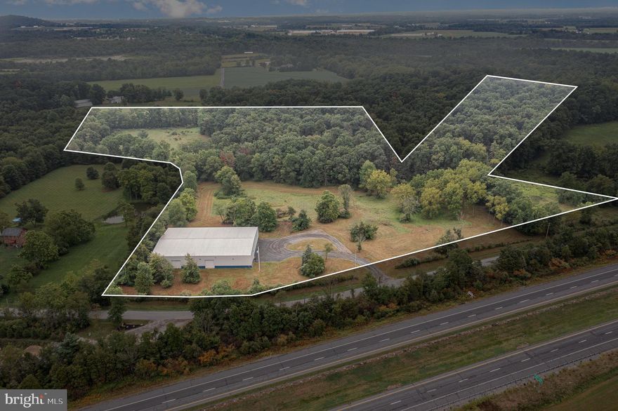 Discover a remarkable industrial property in the heart of York Springs, Pennsylvania, offering endless possibilities for your commercial ventures. This expansive 26-acre parcel, zoned for commercial and industrial use, boasts a recently constructed 15,000 square foot clear span steel storage building, providing a blank canvas for your business dreams.

This property is Situated near the intersection of two major highways and offers excellent accessibility and visibility. The strategic placement, just 20 miles north of the Maryland State Line, positions your business in a thriving corridor with ample growth potential.

The current owner envisioned a state-of-the-art baseball and sports training facility with five ball fields, concession stands, and ample parking. Plans for a lobby annex and adjoining batting cage building are already on file, offering a turnkey opportunity for sports enthusiasts. However, the versatility of this property allows for a multitude of uses limited only by your imagination.

The commercial-industrial zoning permits a wide array of business opportunities. The possibilities are endless, from agricultural equipment sales and service to heavy equipment repairs, mini-storage facilities, and even solar energy systems. Conditional uses expand the potential further, encompassing campgrounds, hotels, industrial parks, manufacturing facilities, and transportation terminals.

With its expansive acreage and modern infrastructure, this property is well-suited for warehouse operations, manufacturing, or repair shops. The land is highly developable, with less than 2 acres of wetlands, allowing multiple uses on the same site.

Water is readily available through a well system, while 440V electric service ensures ample power for your operations. A transferable National Pollutant Discharge Elimination System (NPDES) permit is in place, simplifying environmental compliance. It's worth noting that a septic system must be installed to meet your specific needs.

Nearby attractions include Bermudian Springs High School and State Game Lands Number 249, which provide a balance of educational and recreational opportunities. The property's proximity to Gettysburg, Frederick, and other charming Pennsylvania towns adds to its appeal.

Whether you're looking to bring a grand vision to life or seeking a versatile space for your growing business, this York Springs property offers the perfect blend of location, infrastructure, and potential. Don't miss this opportunity to stake your claim in this promising commercial landscape.