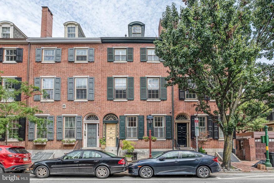 Welcome to this beautiful historic home on an extra wide lot, nestled in the finest location that Society Hill has to offer. This home is brimming with history while also including all of the modern conveniences that you could ask for and more! This incredible home begins with a beautiful vestibule entry with french doors that lead into the handsome living room beaming with character and highlighted by crown molding, marble mantle, plantation shutters, built-in shelving and hardwood flooring. An archway leads into the formal dining room with ornate chandelier and crown molding. Stunning and spacious kitchen with breakfast area, 6-seater island bar counter, quartz countertops, stainless steel appliances including a 6 burner Viking stove, exhaust fan and pot filler, travertine tile flooring and tons of natural light. Sliding doors lead out to the beautiful red brick landscaped garden patio with trees and shrubbery - the perfect spot for summer BBQs or enjoying quiet evenings with wine and a book! On the second floor you'll find a fantastic family room with a wet bar, laundry closet, 3 windows and sliding glass doors onto a charming deck overlooking the garden. The main bedroom suite features a gas burning fireplace with original mantle, window, recessed lighting, large walk-in closet with built-in shelving and cabinetry, a sitting area and a full carrera marble bath with oversized stall shower and double vanities. Off the hall there is a door out to a rooftop with deck potential! The third floor features two bedrooms with a jack-and-jill bathroom, plus hallway closets. Steps lead up to a dormer bedroom suite complete with a sitting area and full tile bathroom. The finished basement makes the perfect den, family room or office with tons of closet space, powder room and door to the garden, plus an entire storage room and mechanical room. Amazing location that's convenient to Center City business and historical locals, restaurants, shopping, transportation, parks, the waterfront, and the South Street business district. Includes 1 year pre-paid parking at Independence Place or 2nd and Lombard St. Must see to believe!